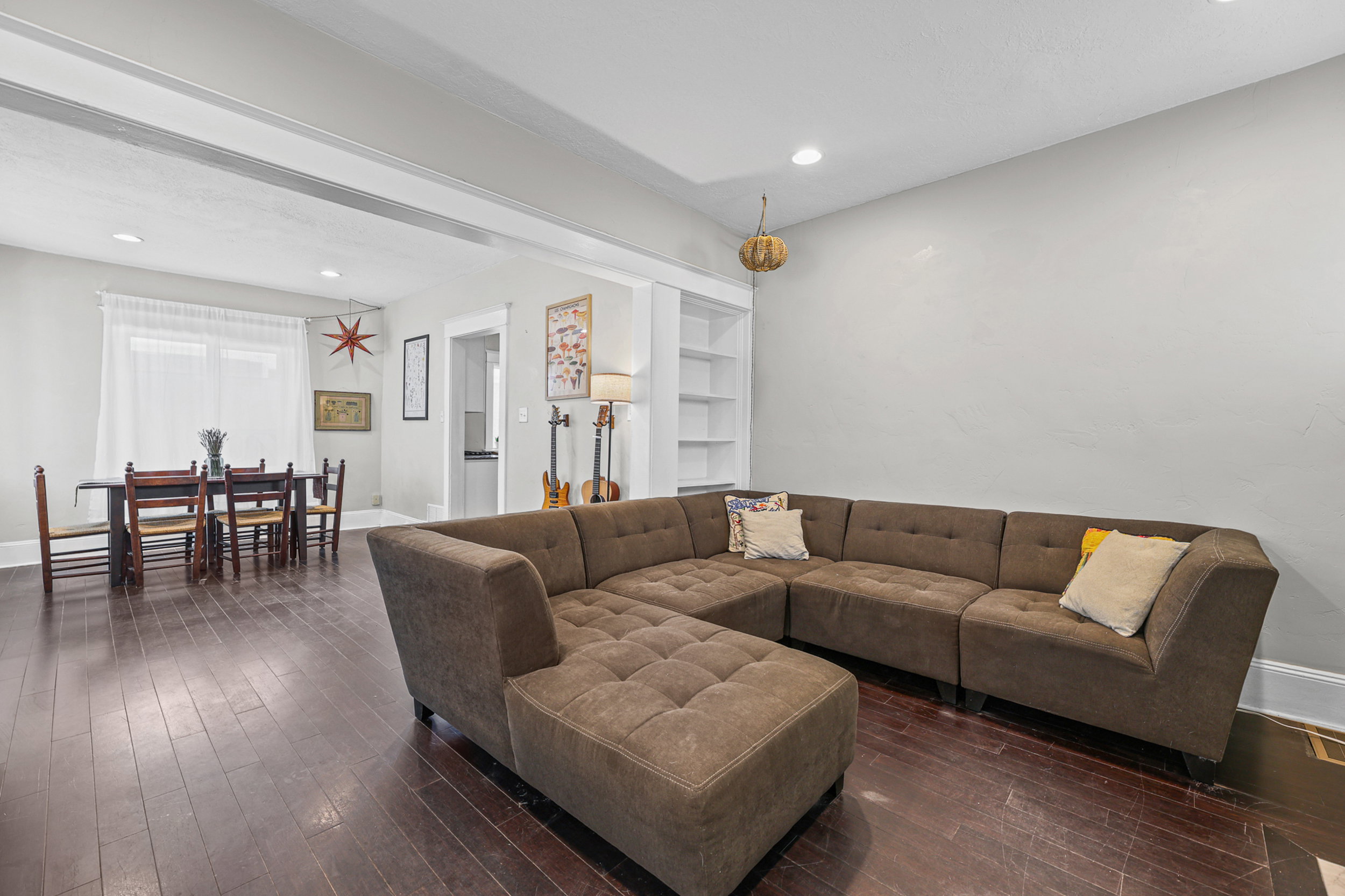 Open-concept living area featuring wood-finish flooring, recessed lighting, and built-in shelving