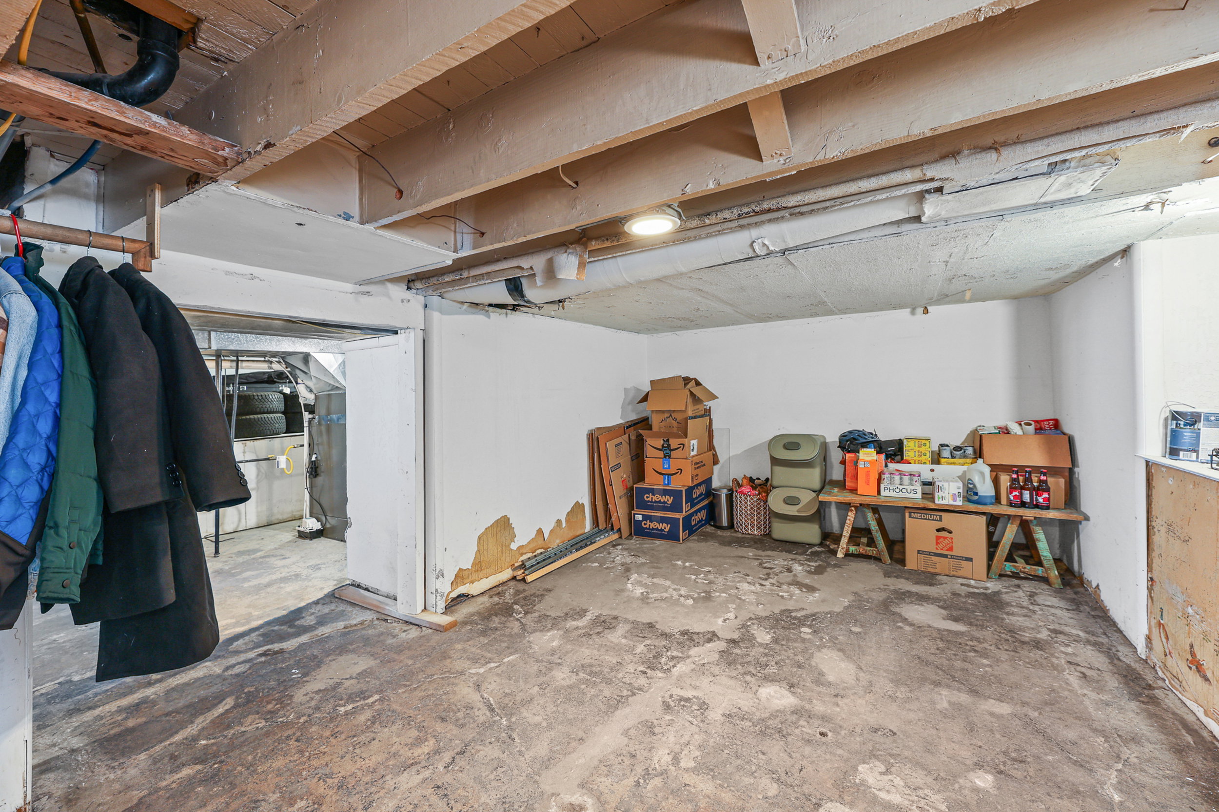 Unfinished basement with exposed ceiling joists and concrete flooring