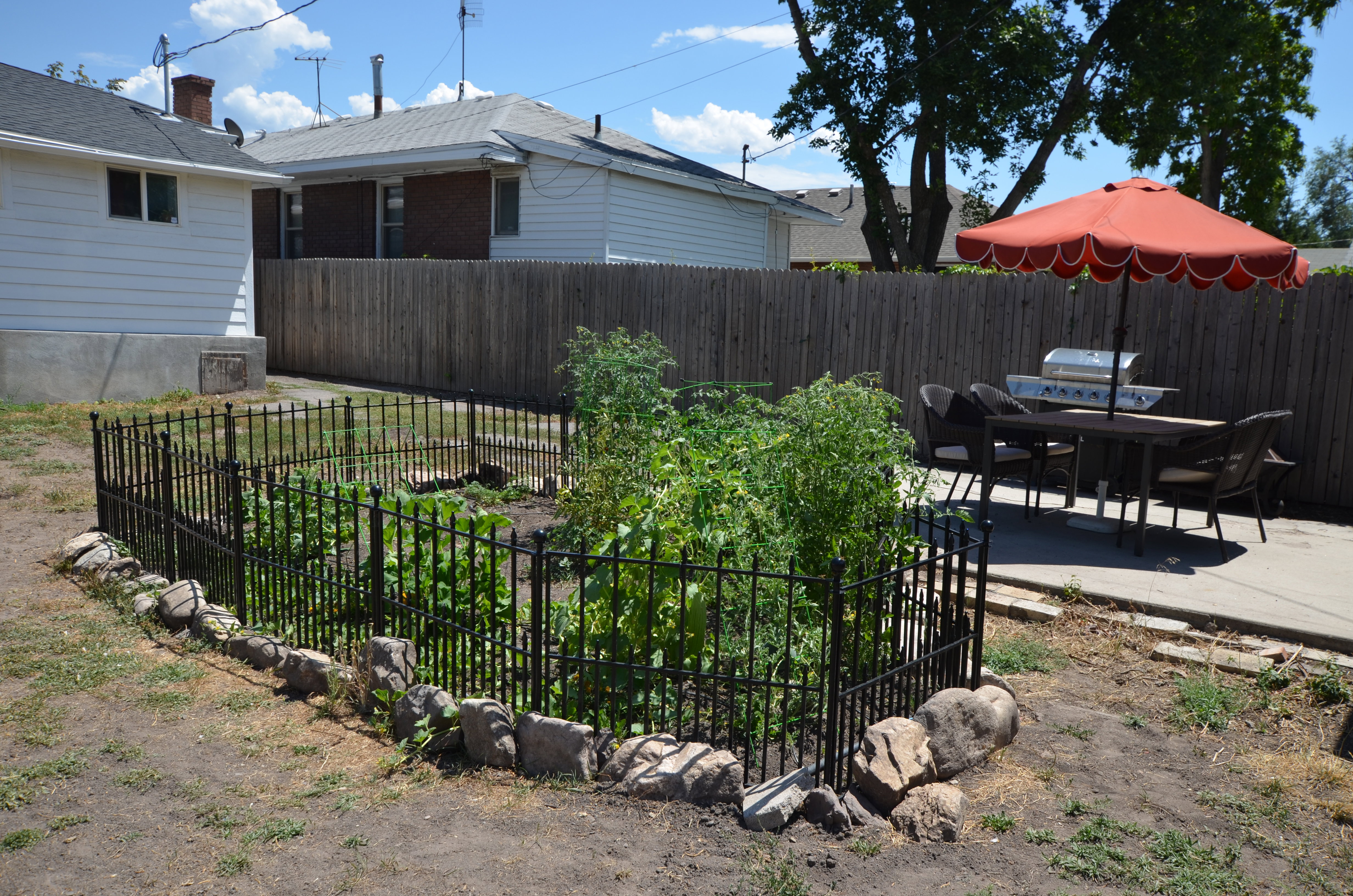 Private backyard featuring a fenced garden area, a concrete patio, and a wood privacy fence