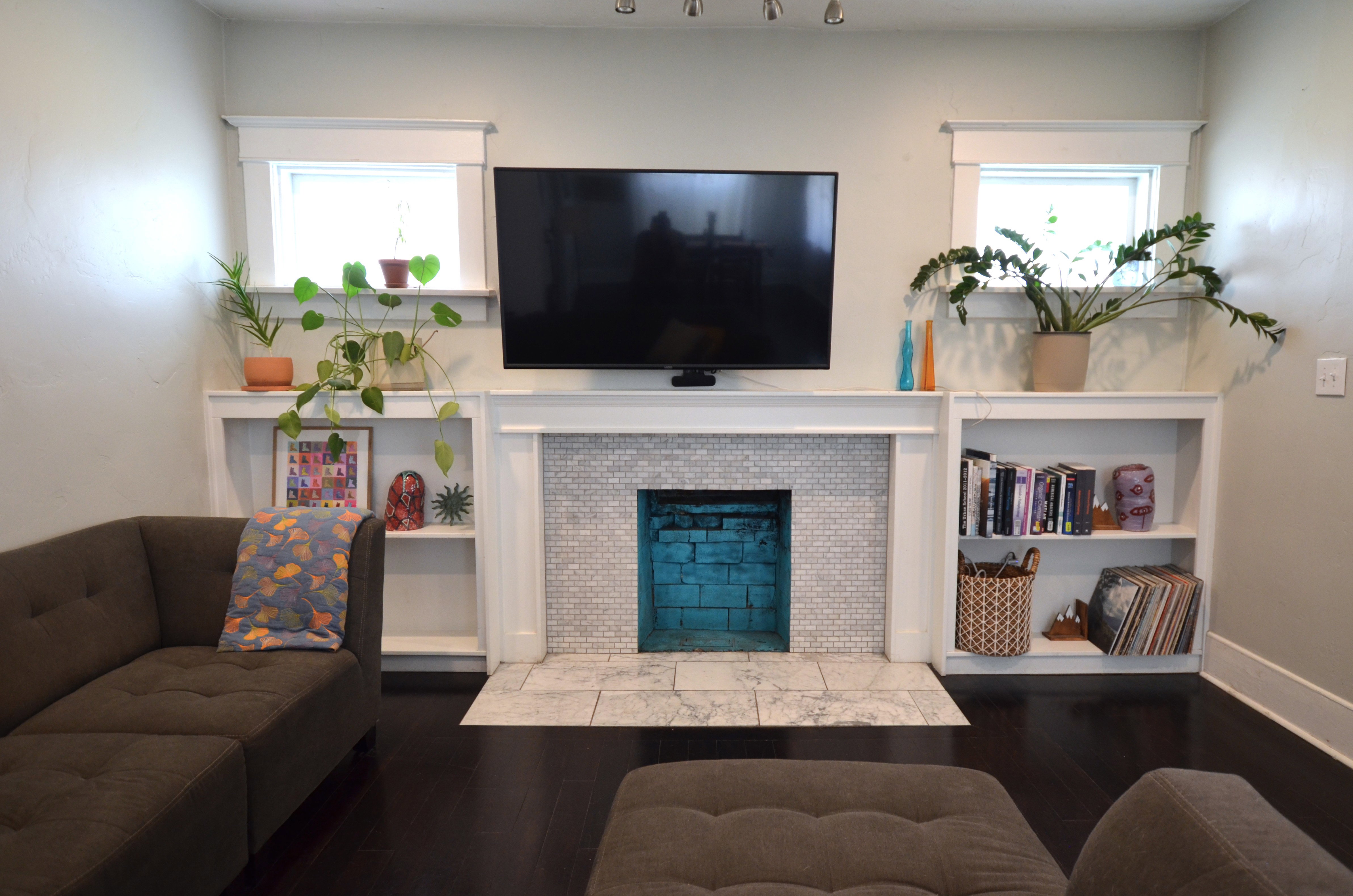 Fireplace featuring white mosaic tile surround and a contrasting blue brick interior
