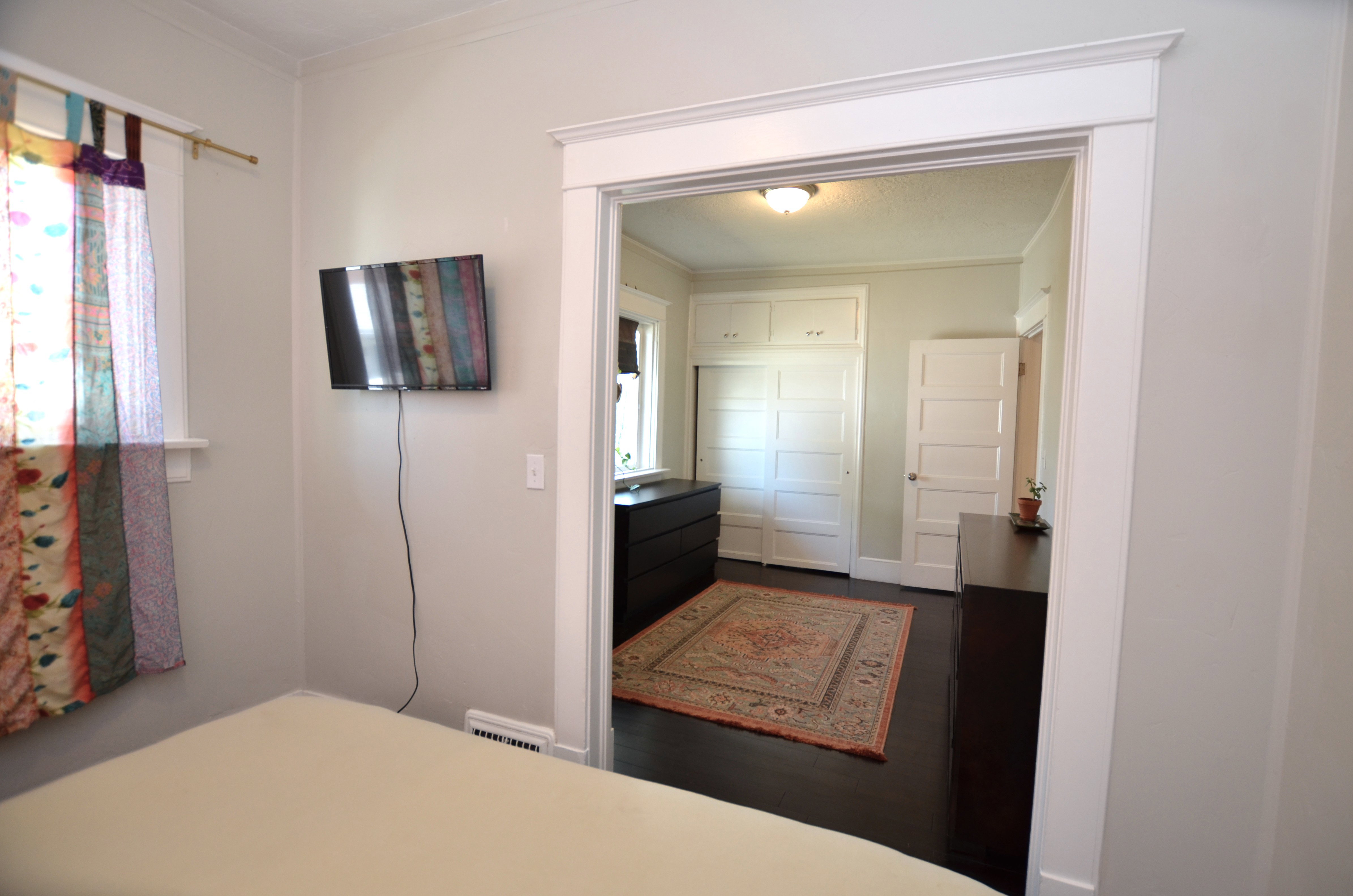 Entryway featuring detailed white trim work, dark wood-finish flooring, and white paneled doors