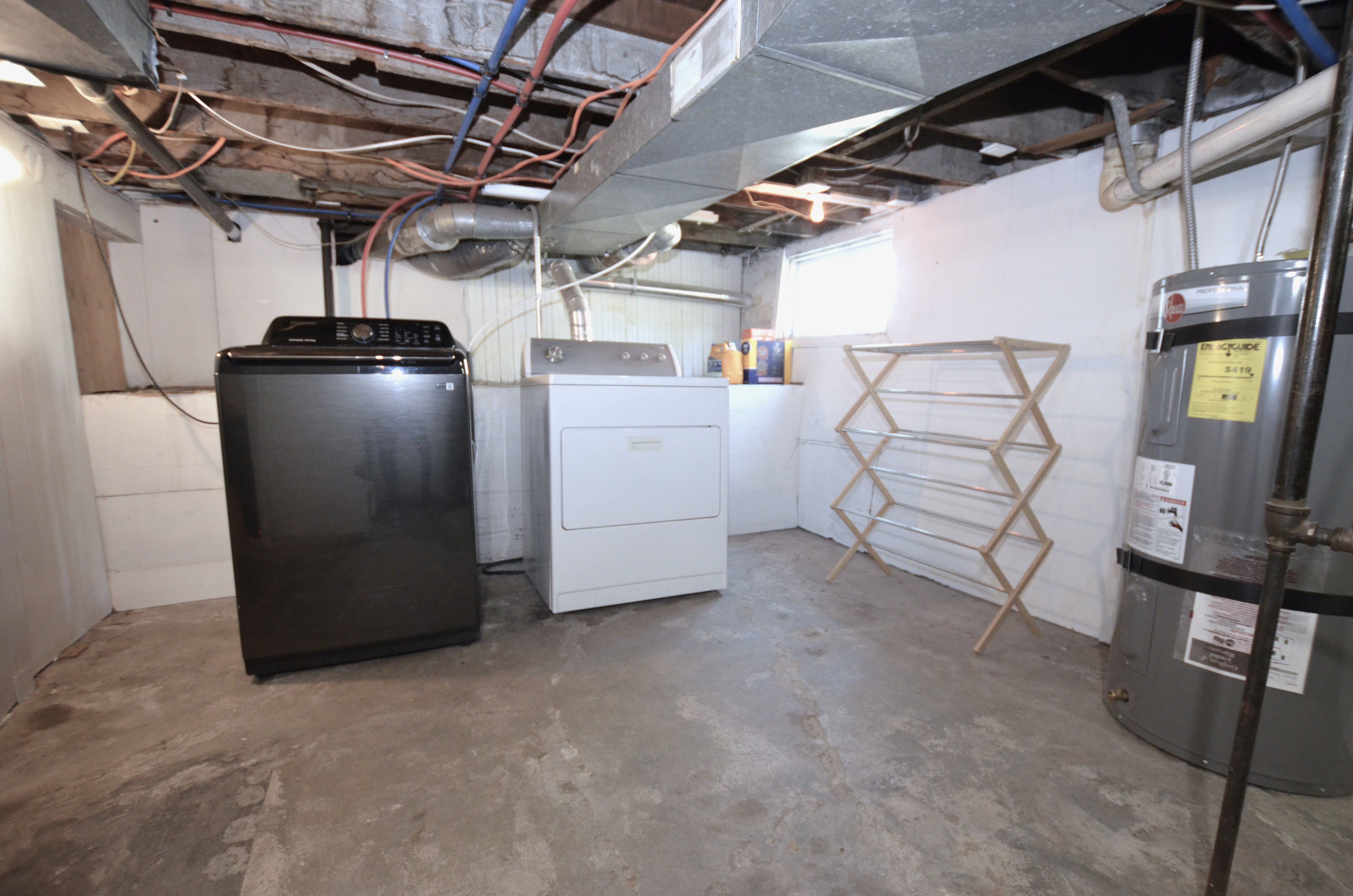 Concrete utility area featuring exposed ceiling joists and ductwork