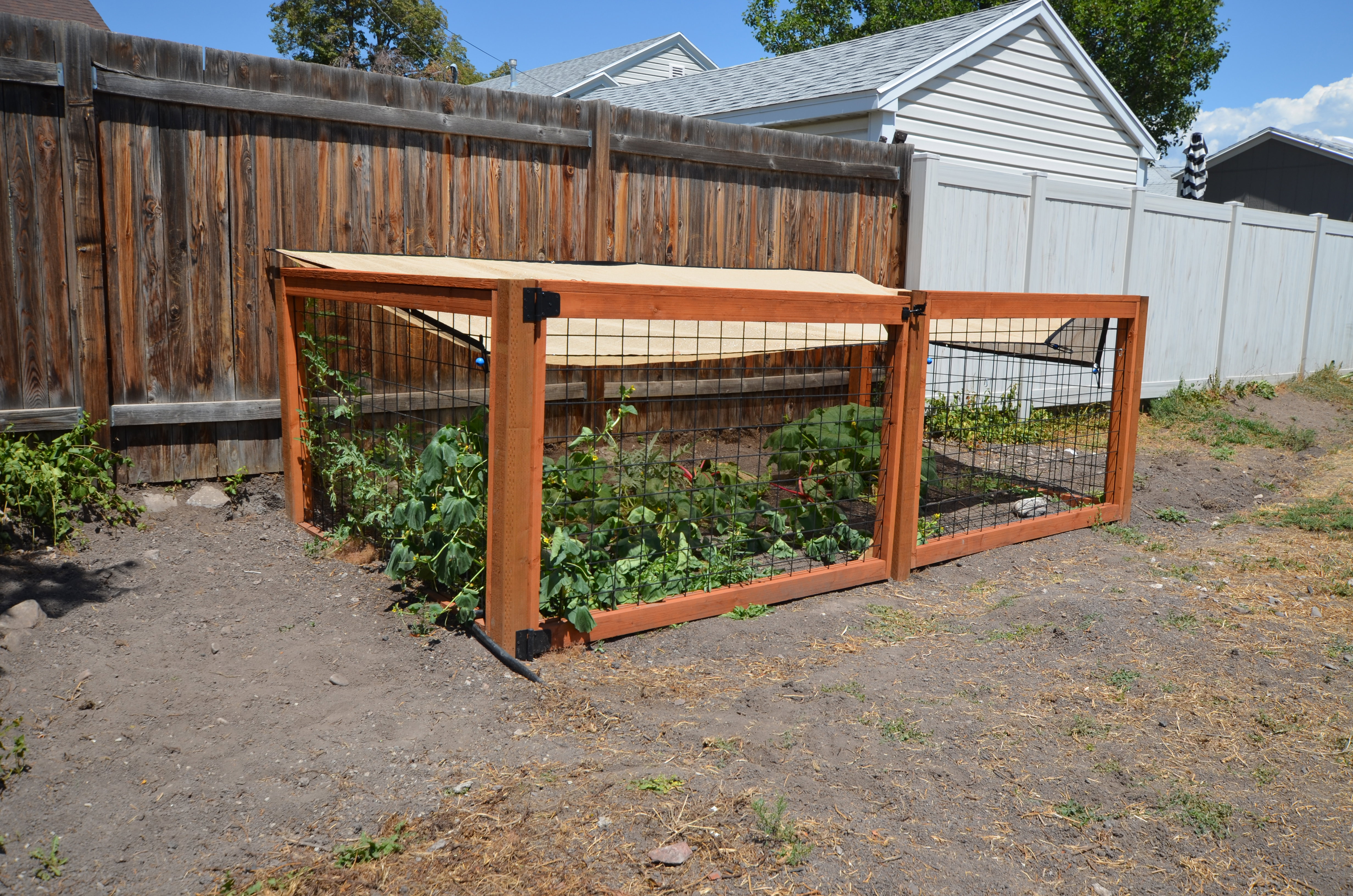 Garden enclosure with wood-frame construction, mesh sides, and a sunshade top