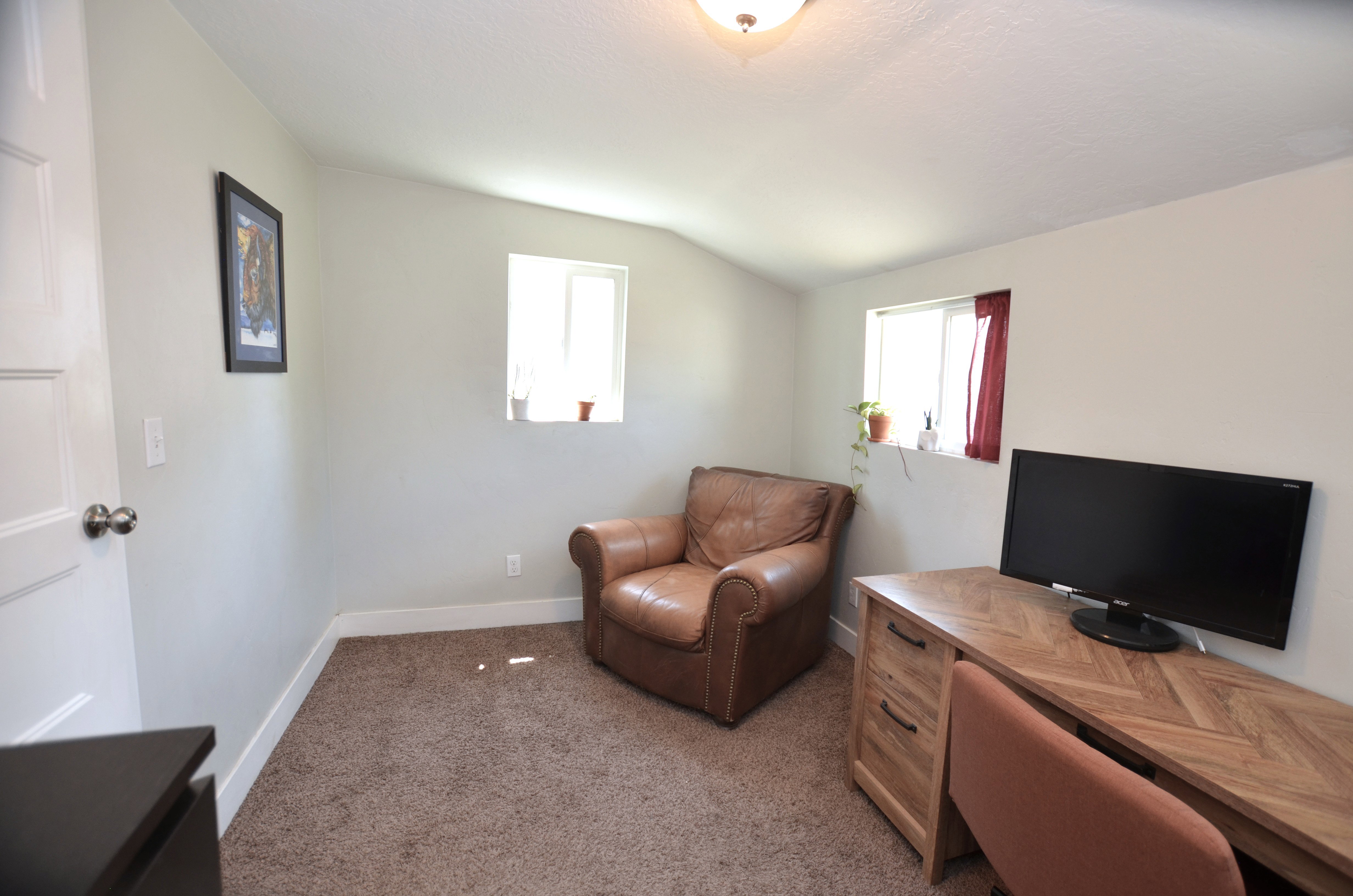 Room featuring neutral wall paint, textured carpeting, and white baseboards