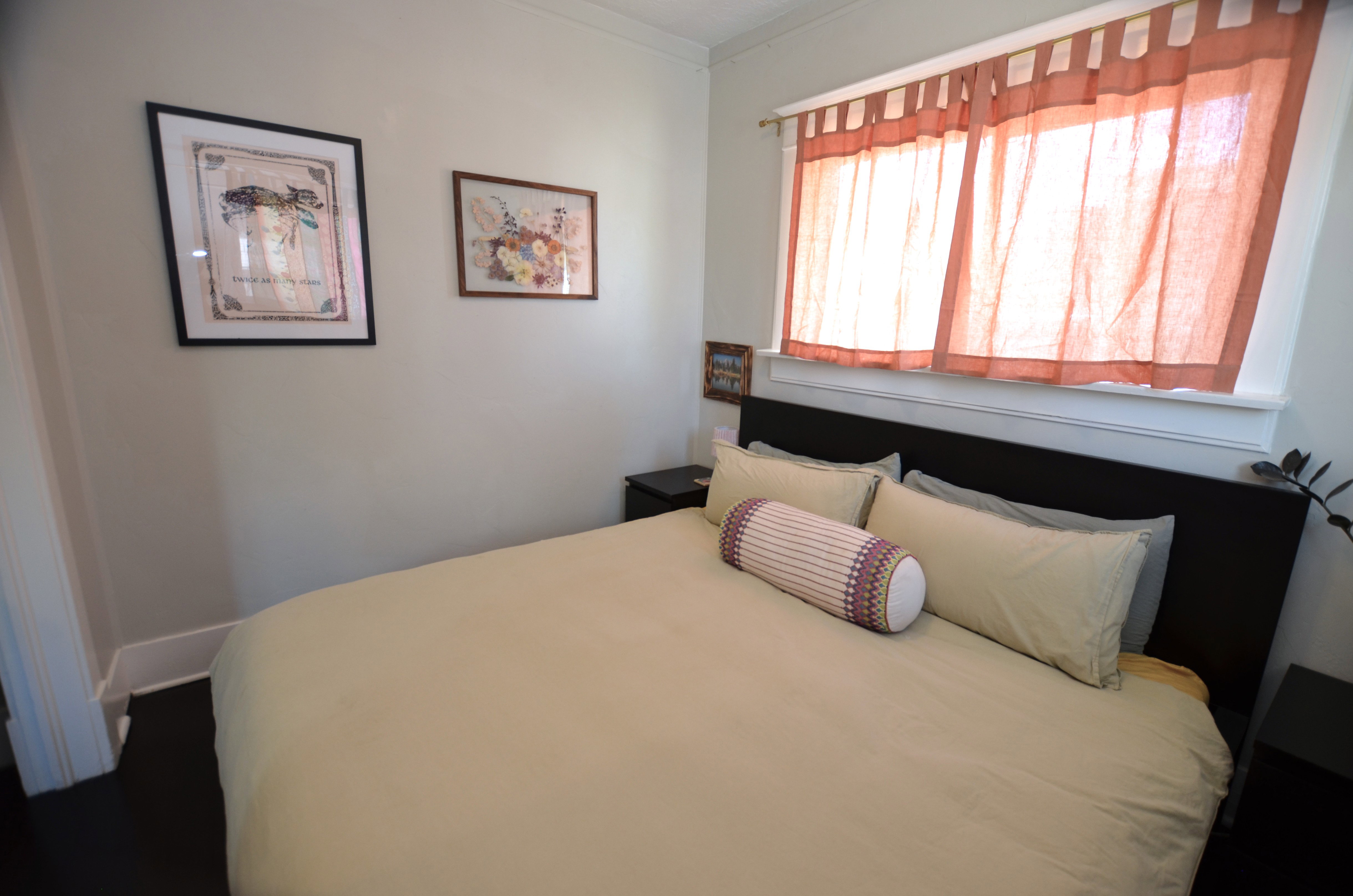 Neutral wall color, dark wood-finish flooring, and a window with white trim