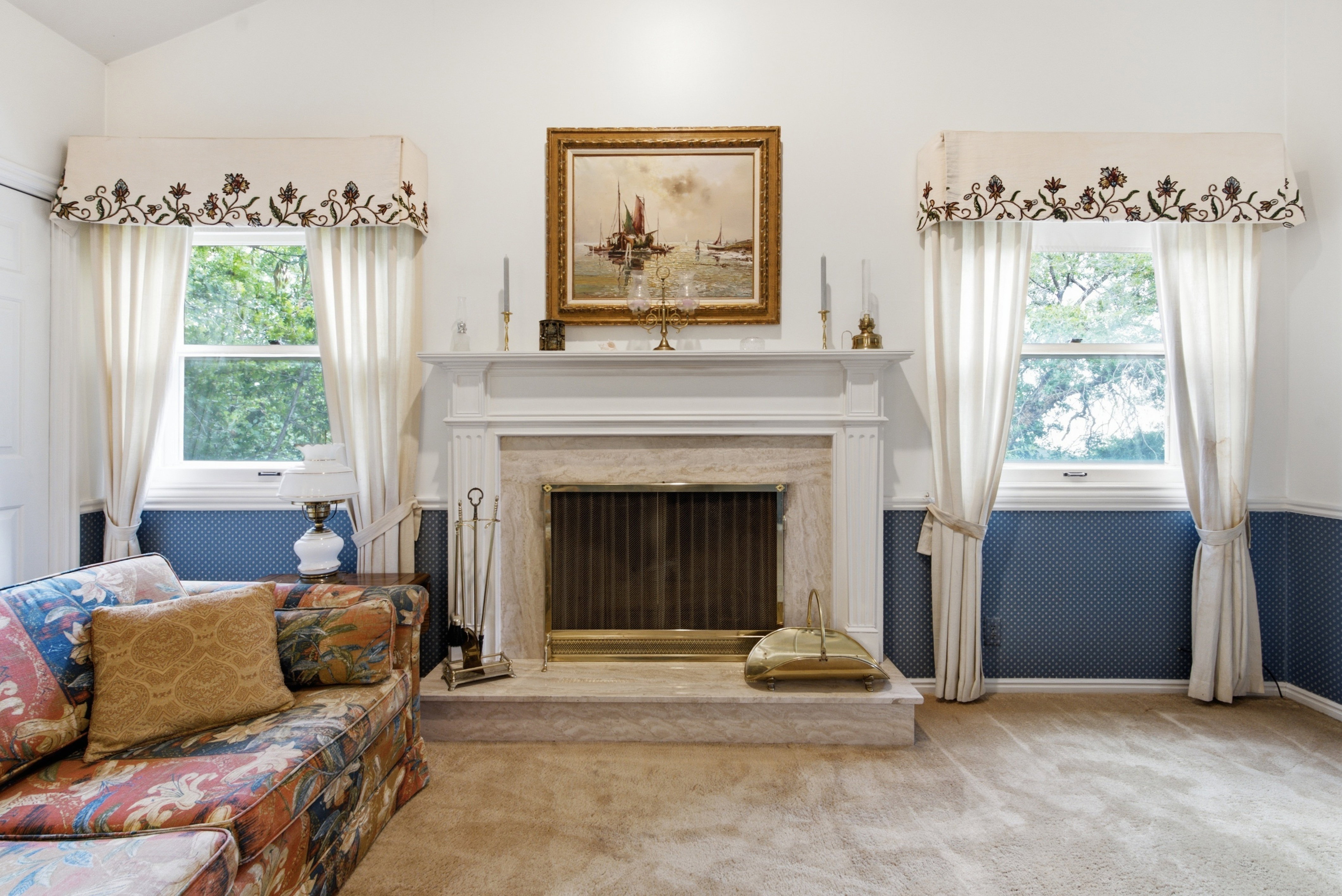 Fireplace with a stone surround and hearth, flanked by two double-hung windows