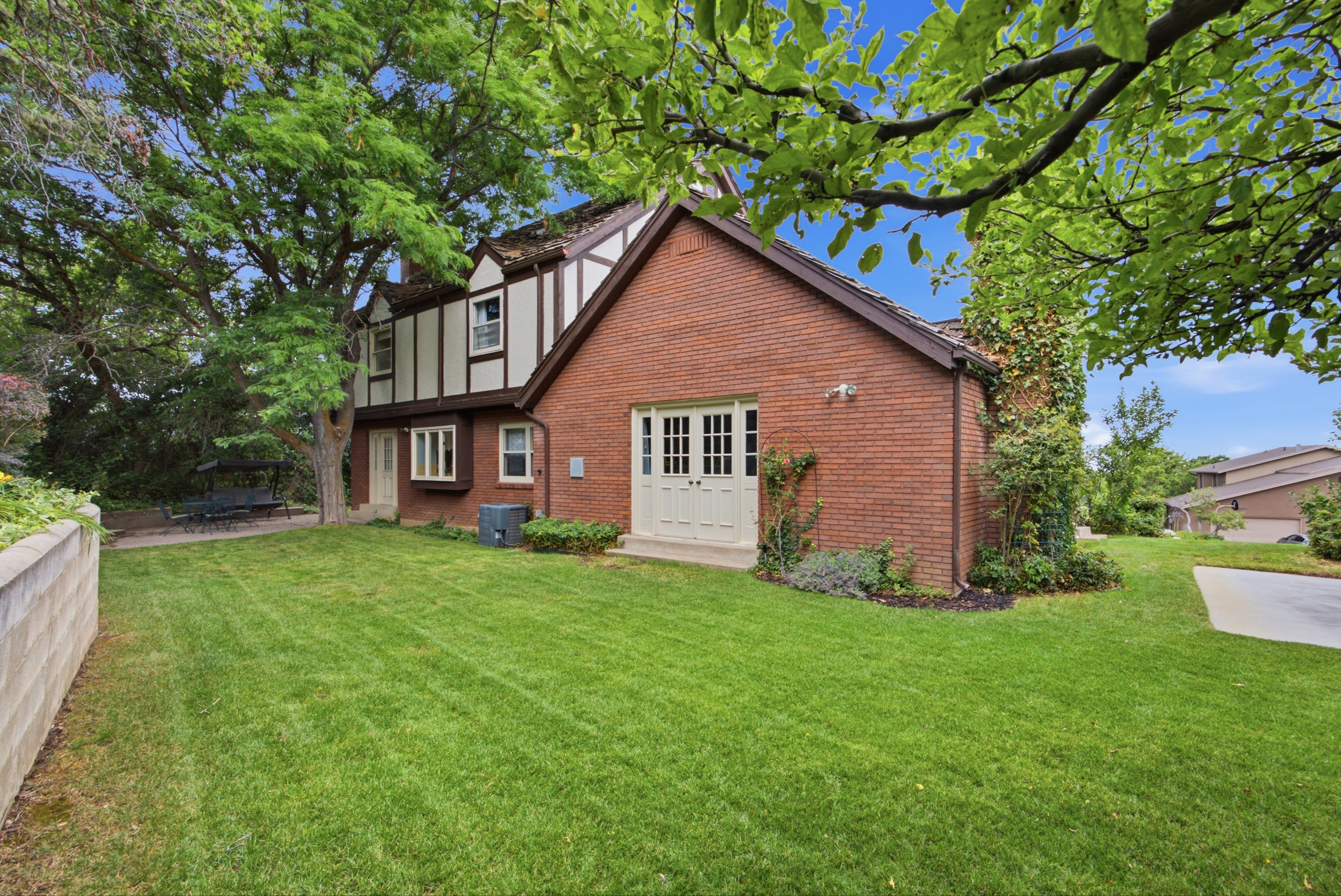 Expansive green lawn with mature trees bordering the property