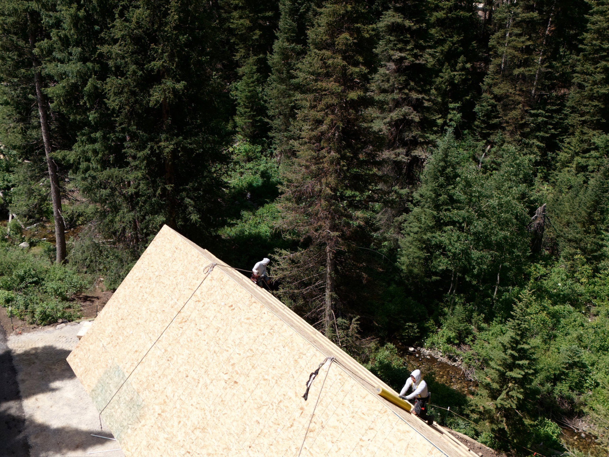 Construction progress showcasing the steep gable roofline, and the Silver Creek river running through the property.