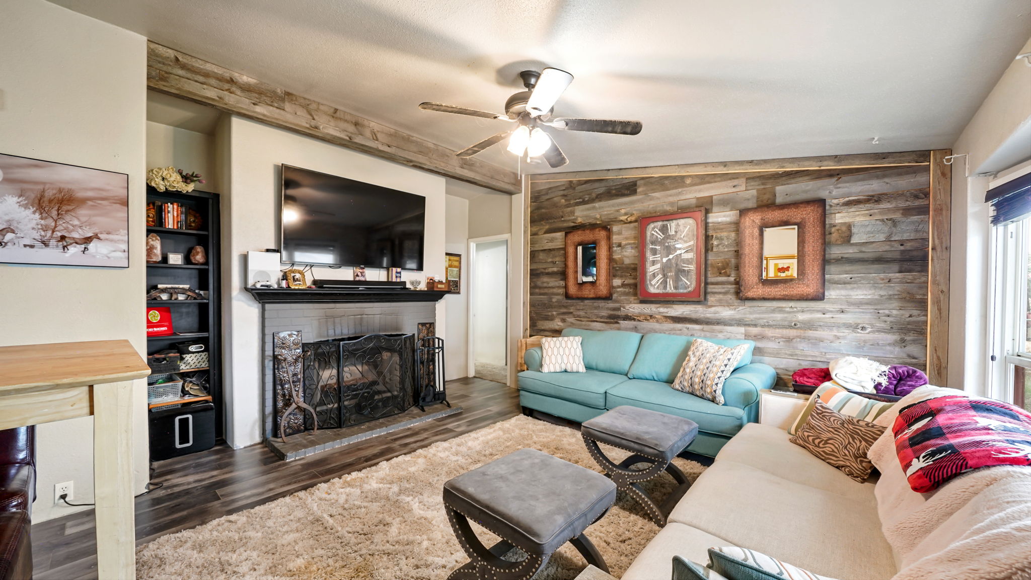 Living area featuring a floor-to-ceiling wood plank accent wall and dark wood-finish flooring