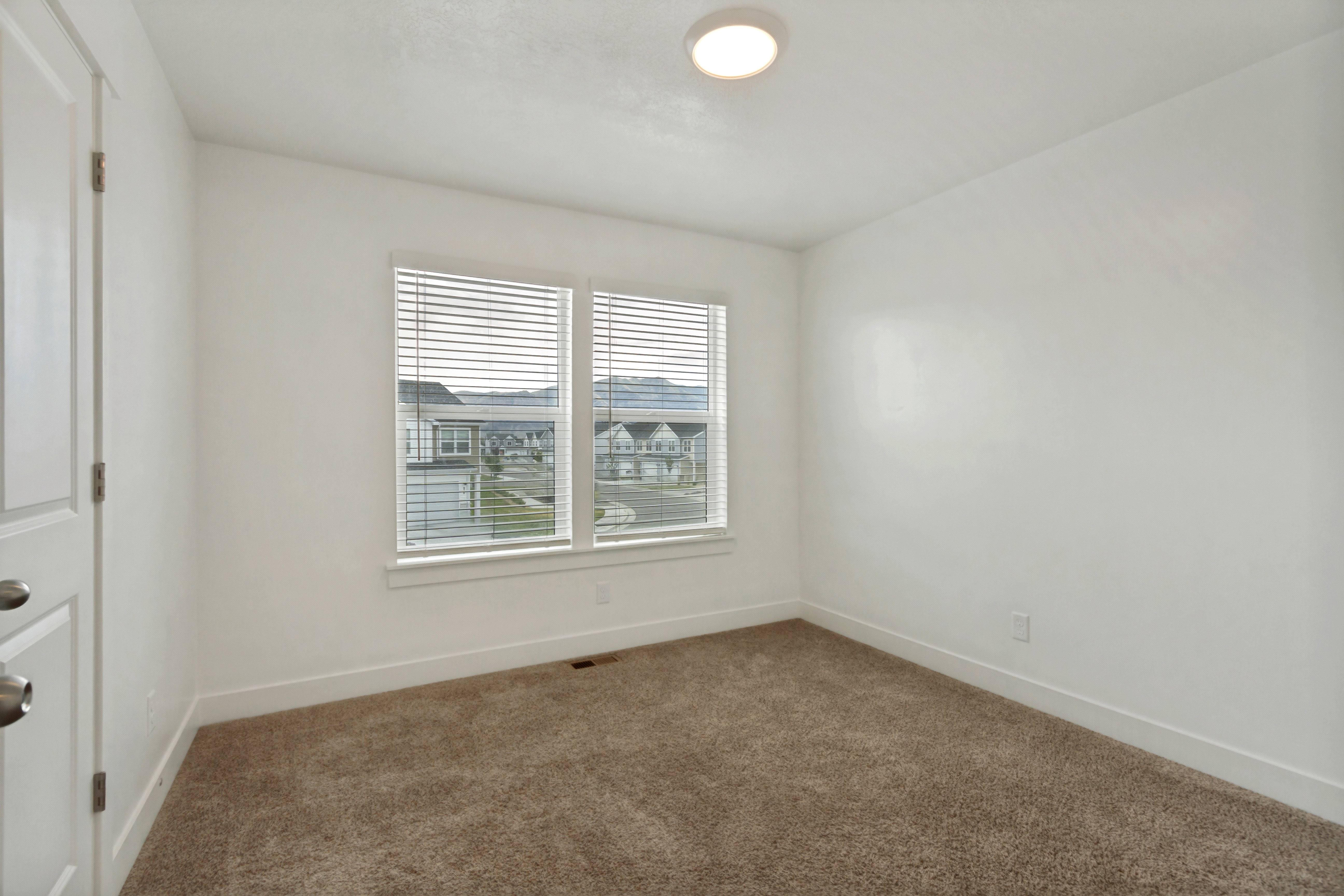 Bedroom two, 2 tone wall finishes, two pane windows, light brown carpet, white baseboards, and a flush mount ceiling light fixture