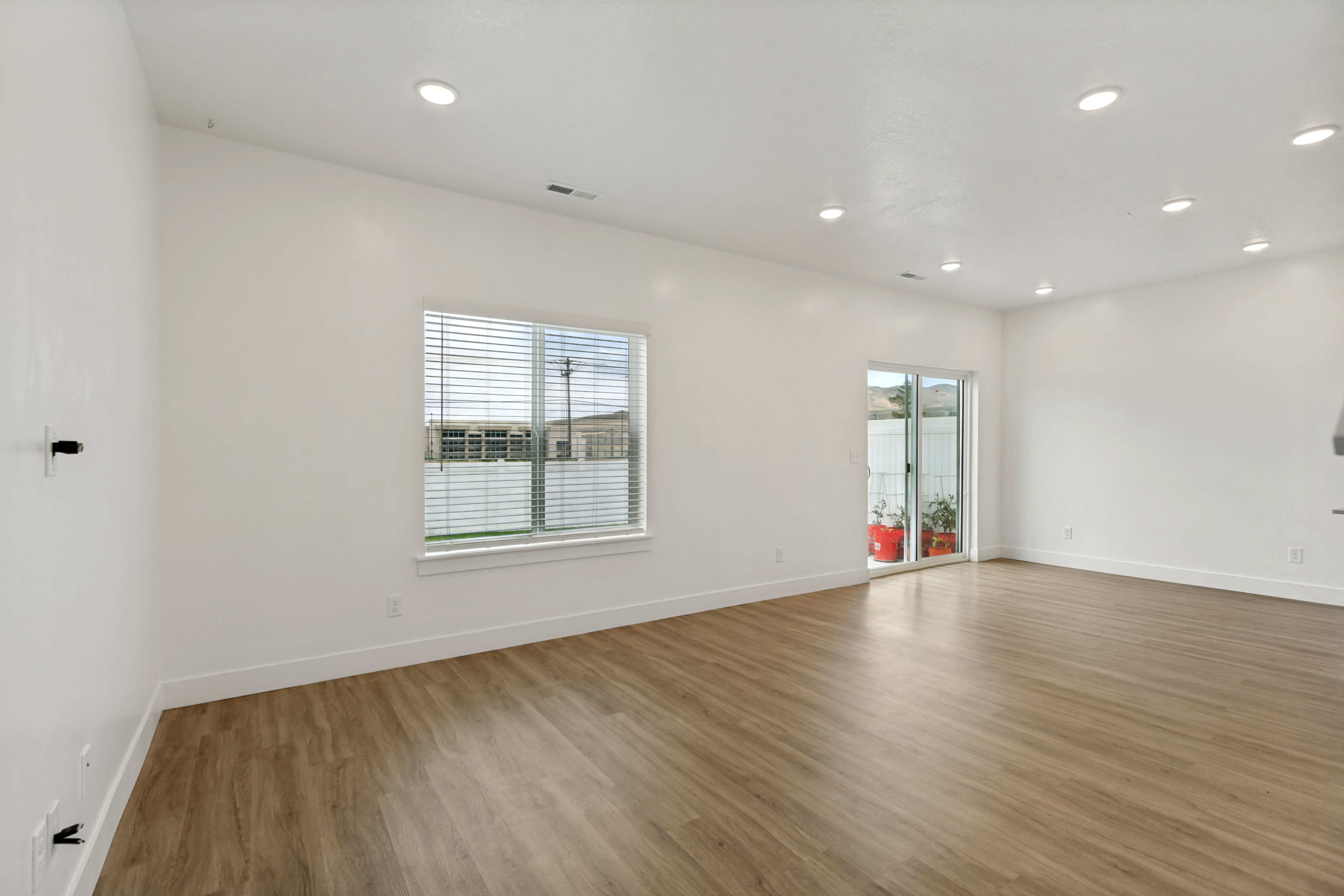 Spacious room featuring wood-finish flooring, recessed lighting, and natural lighting