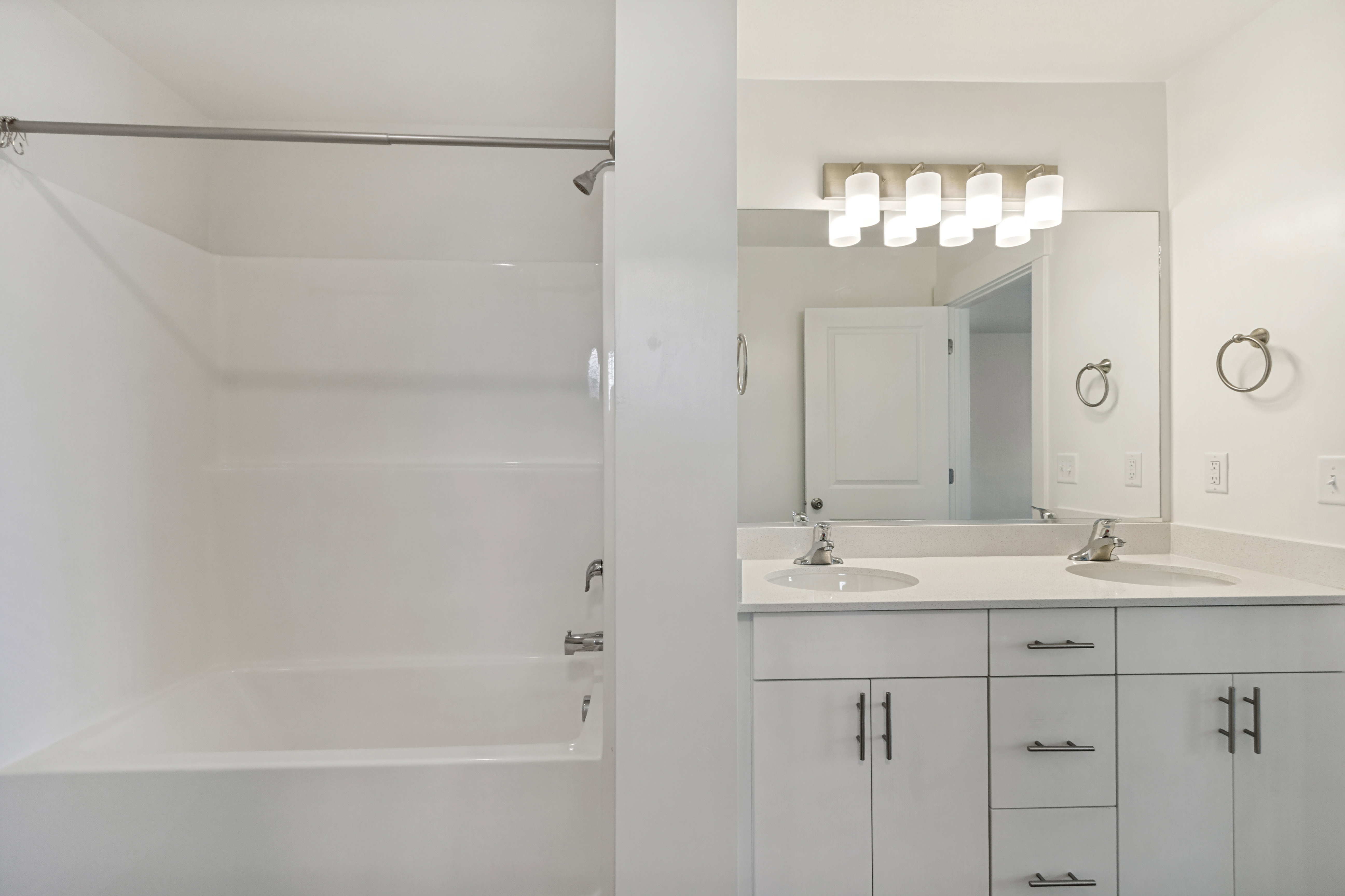 Mast bathroom featuring a double vanity with matching quartz countertops