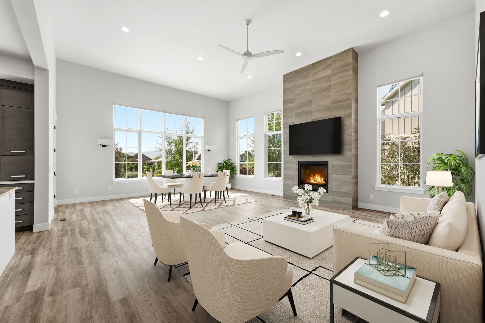 Spacious living area featuring wood-finish flooring, a contemporary fireplace with a tiled surround, and expansive windows