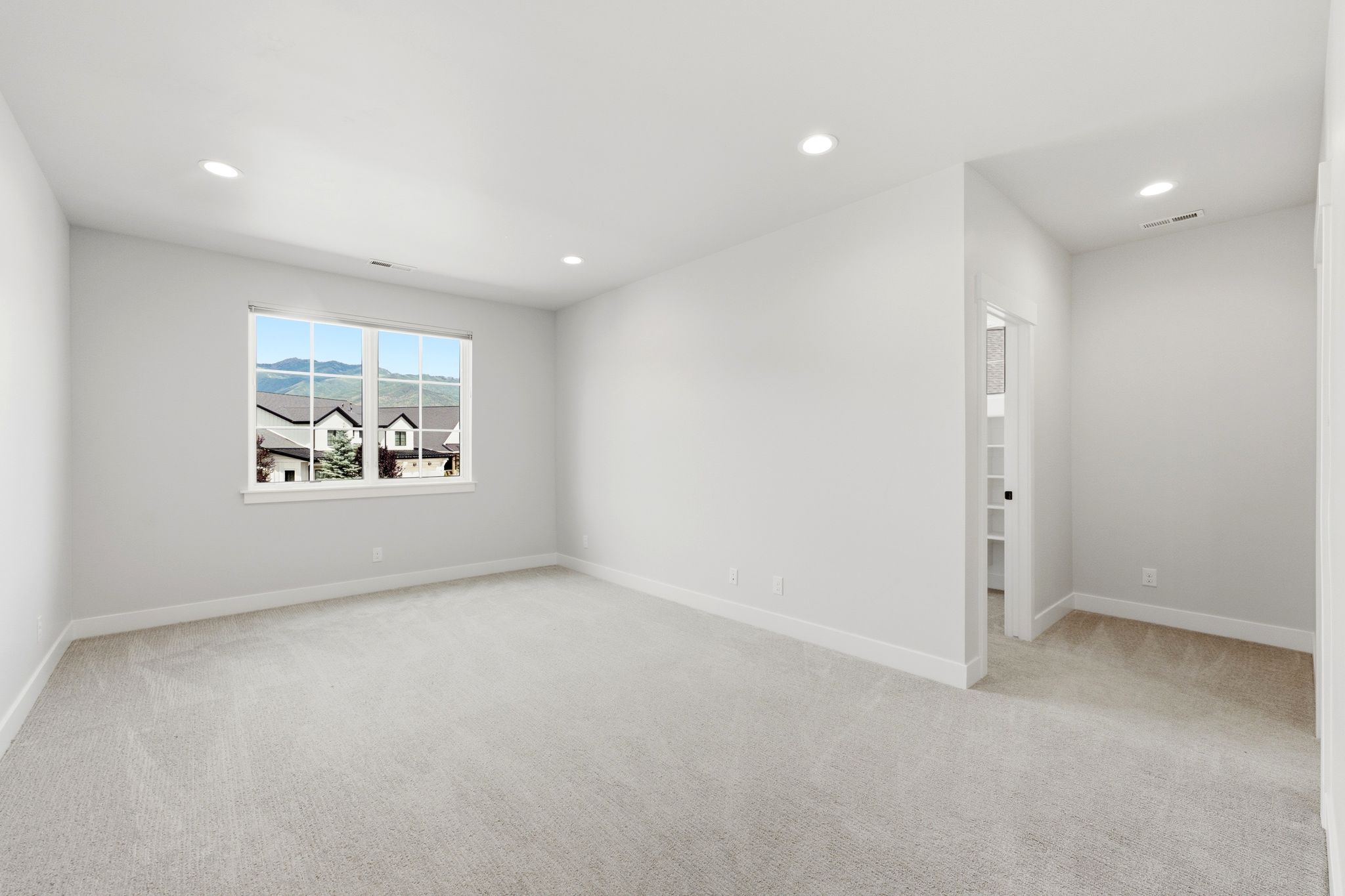 Spacious interior room with light neutral carpet and white trim