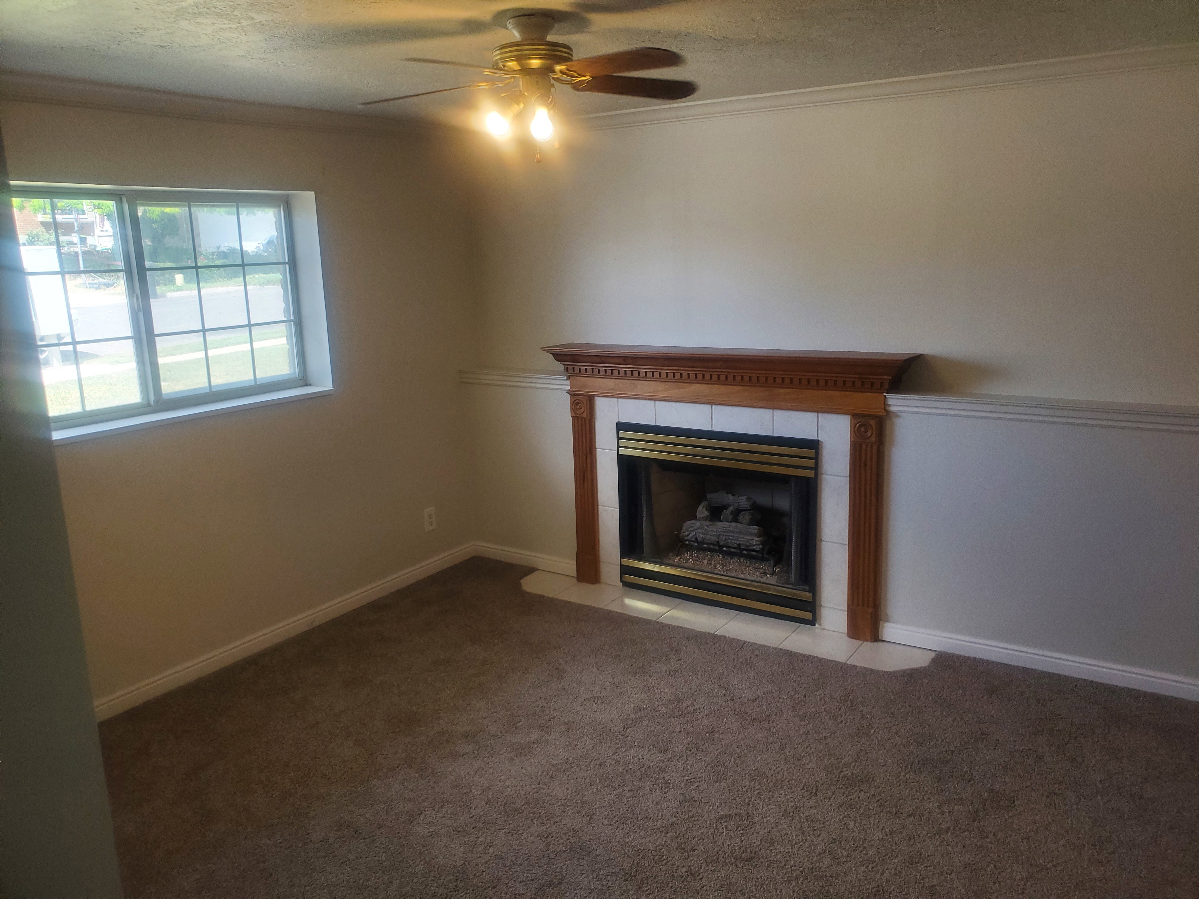 Living area featuring a fireplace with a wood-finish mantel and a tiled hearth