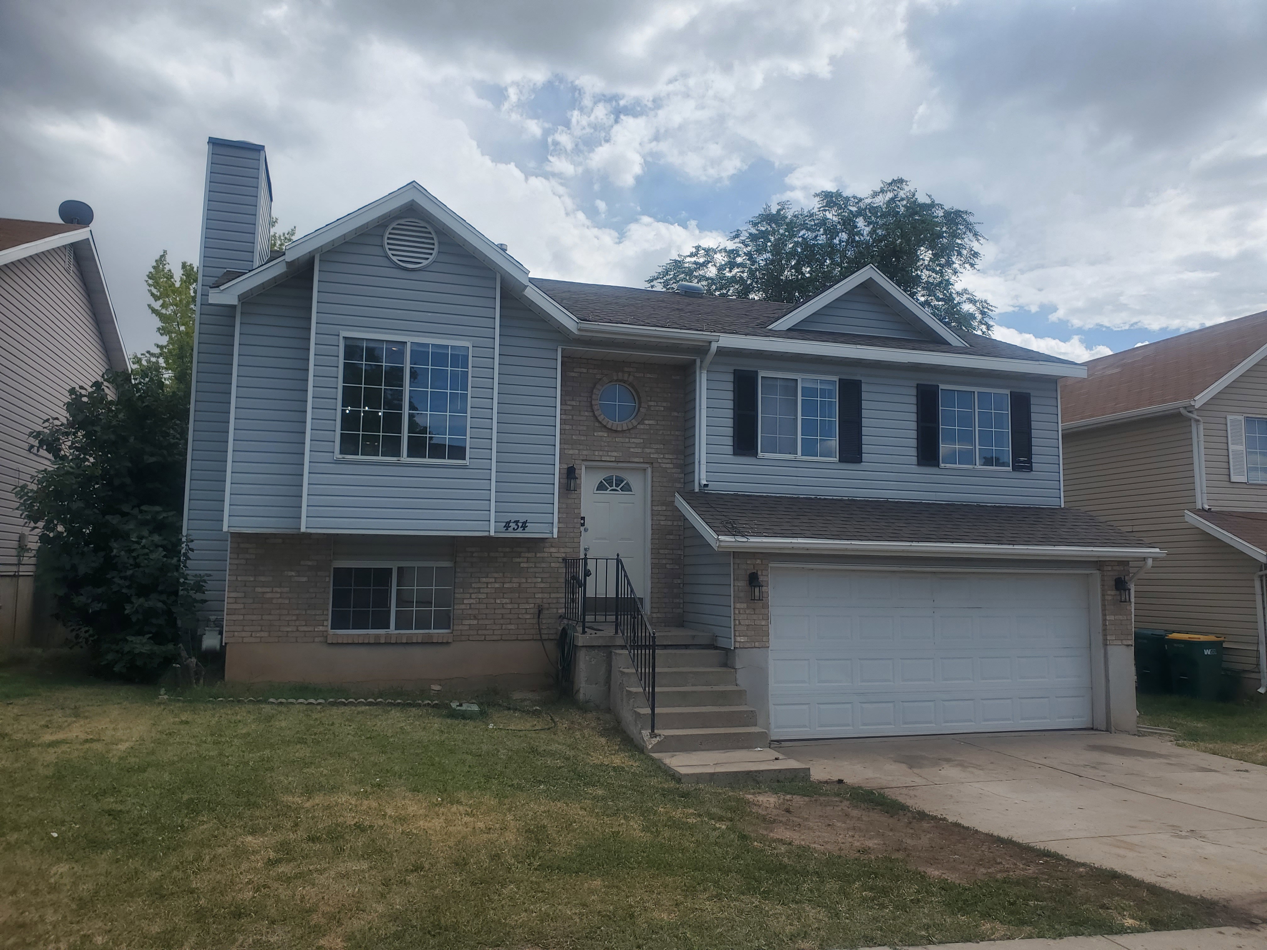 Two-story residence featuring light blue siding and brick veneer
