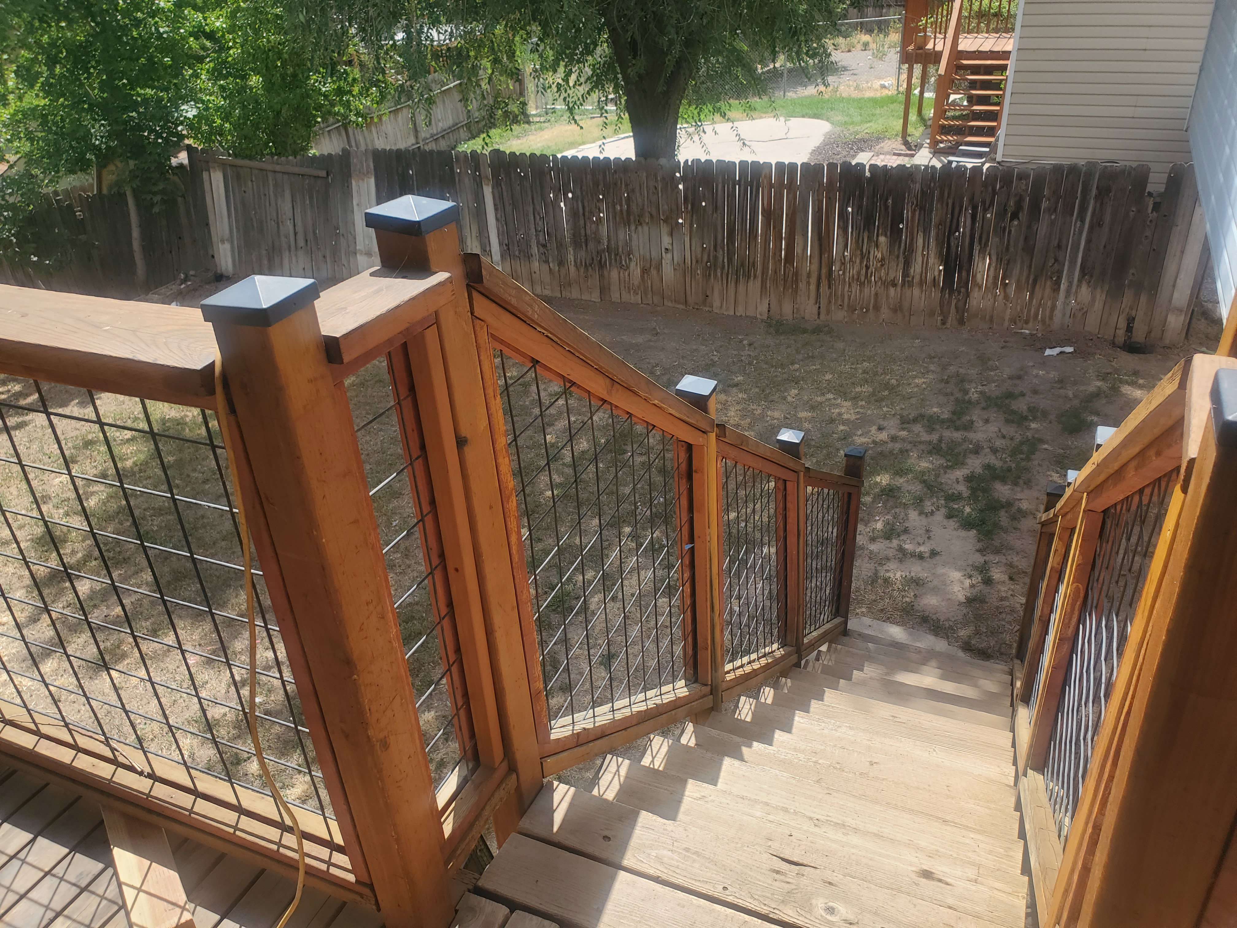 Wood-finish deck with wire-mesh railing and post caps