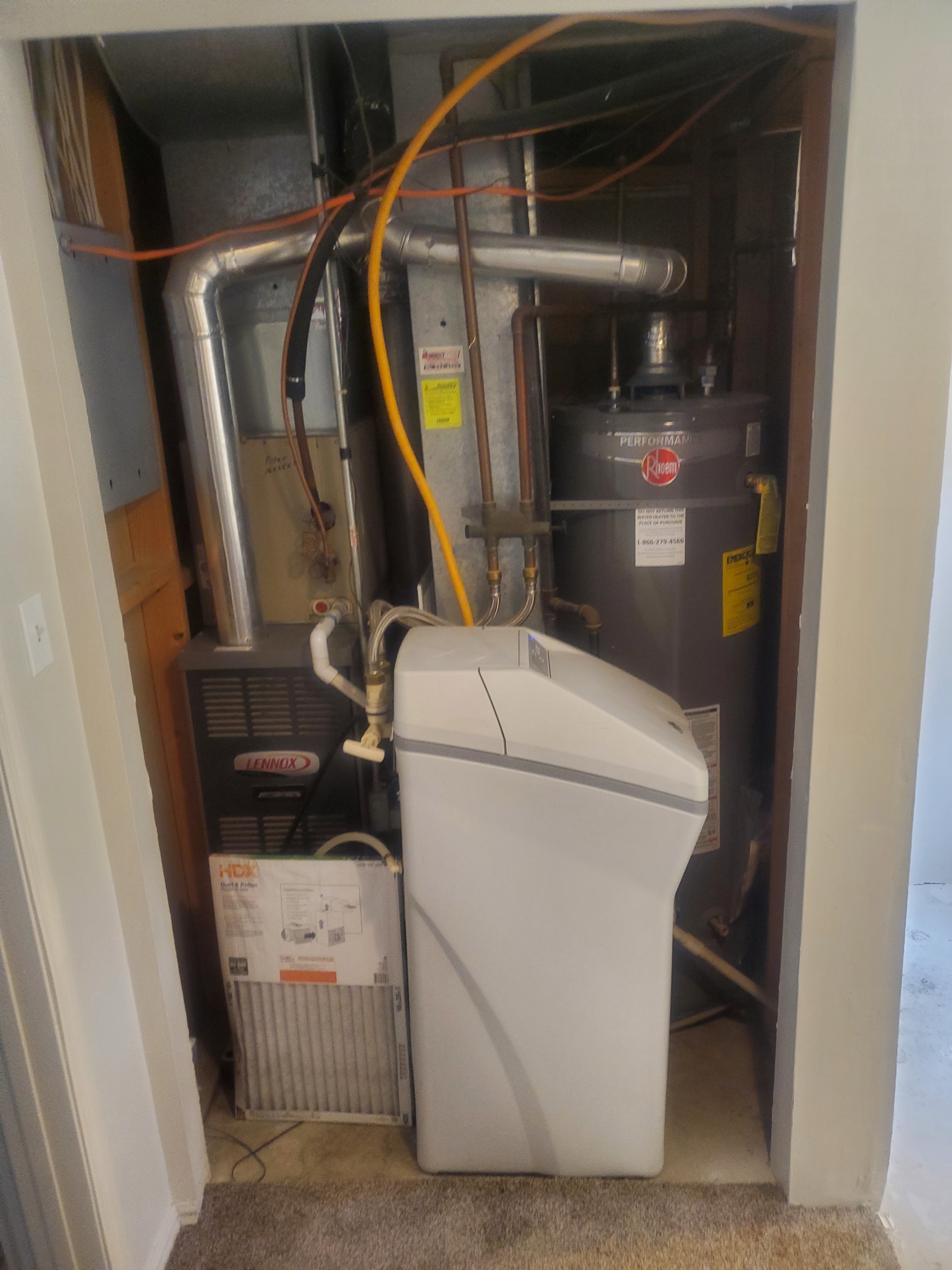 Dedicated utility closet housing a Lennox furnace, Rheem water heater, and a water softener system