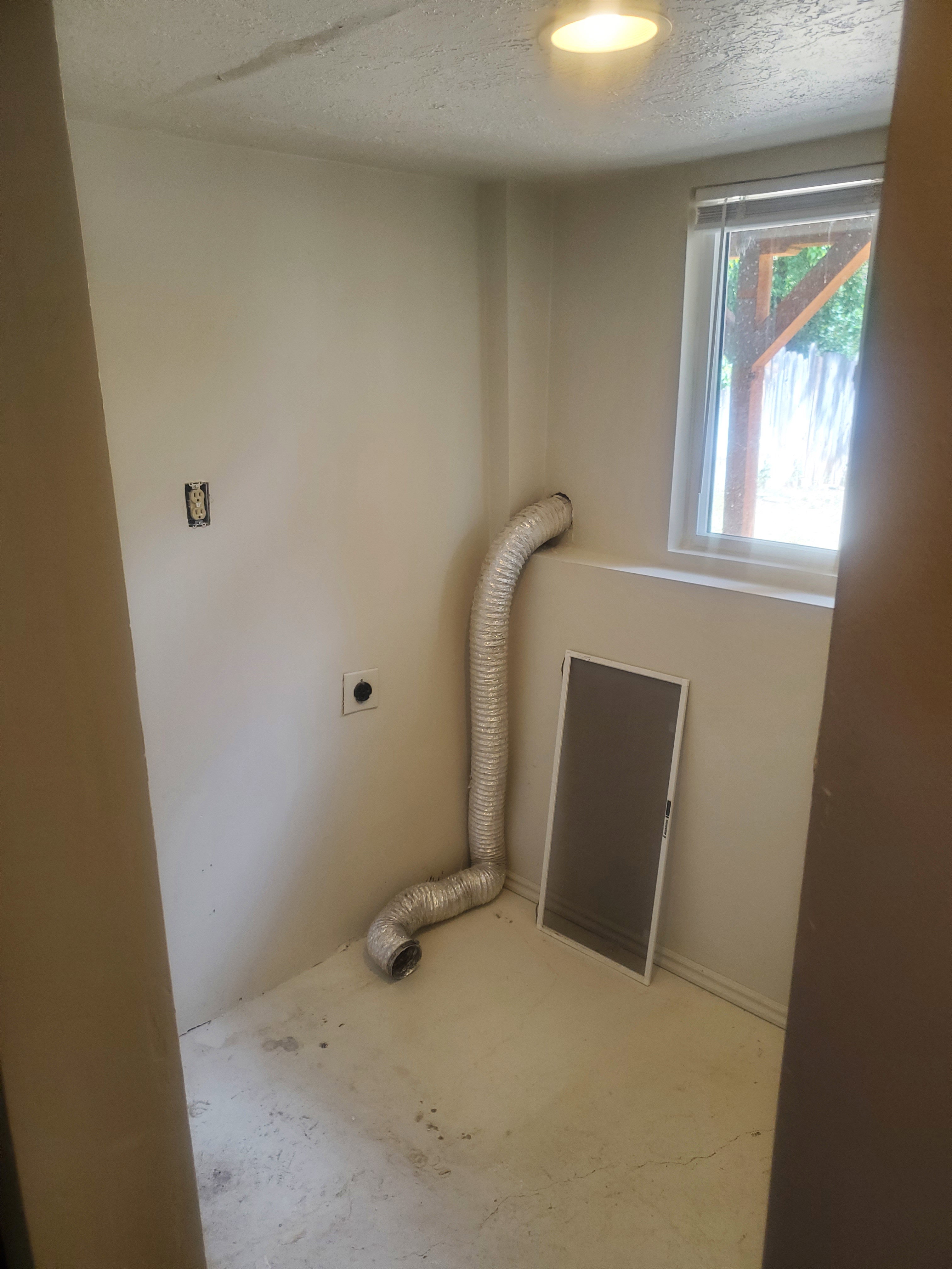 Utility room featuring a window, overhead lighting, and white walls