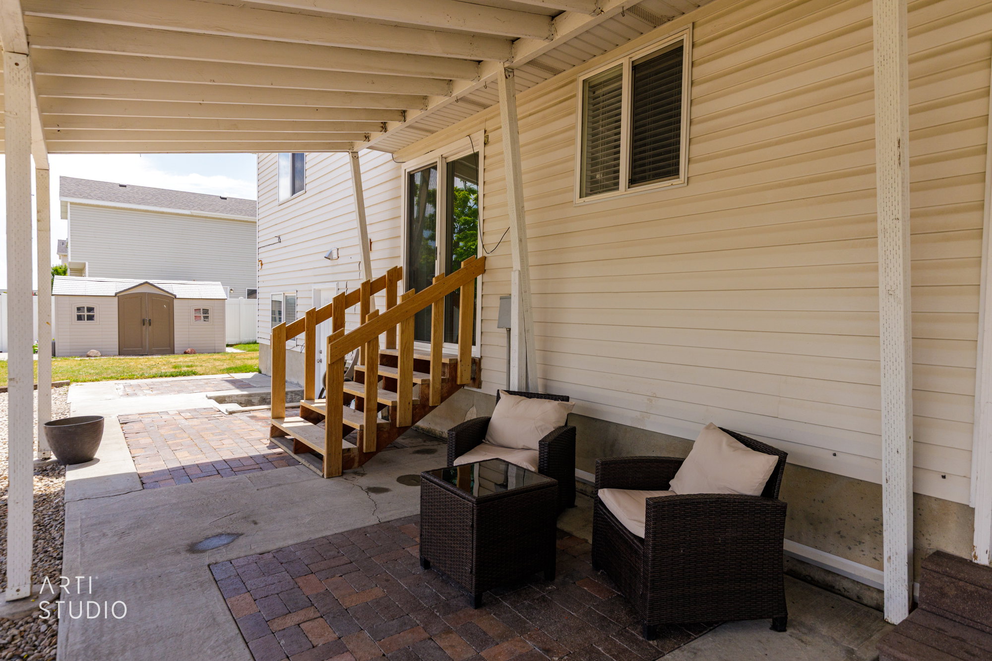 Covered patio with a concrete slab and brick paver accents