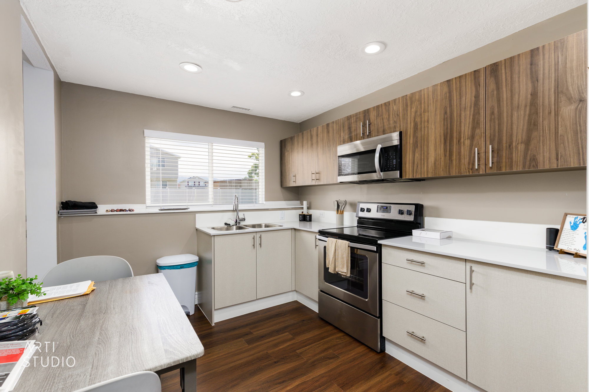 SECOND KITCHEN Modern kitchen featuring wood-finish flooring, two-tone cabinetry with upper wood-look cabinets and lower light-toned cabinets, stainless steel appliances, white countertops, and recessed lighting
