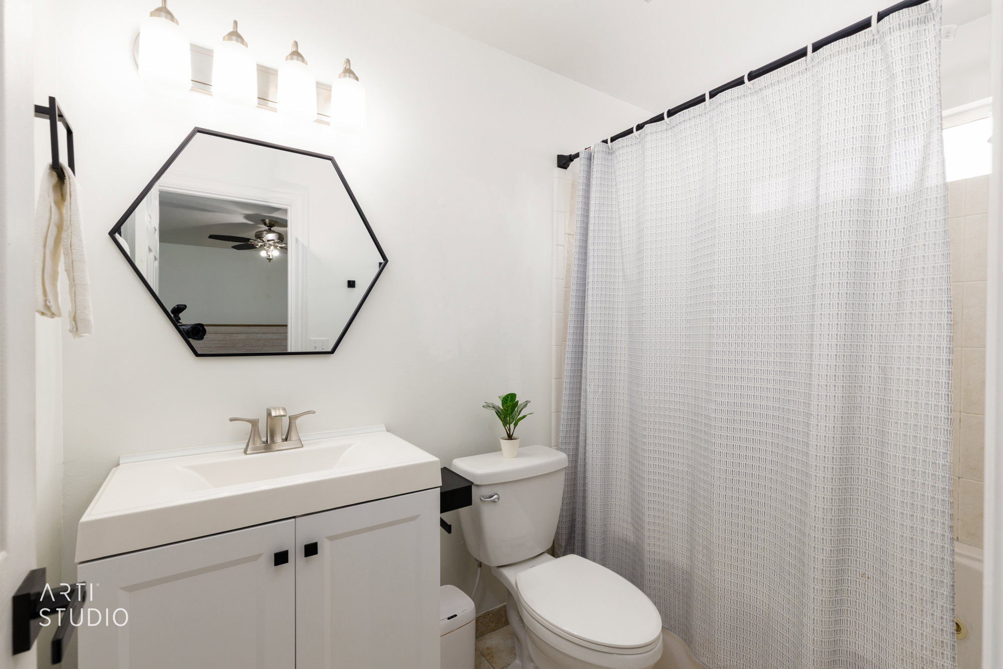 White vanity with integrated sink, brushed nickel faucet, and matte black cabinet pulls