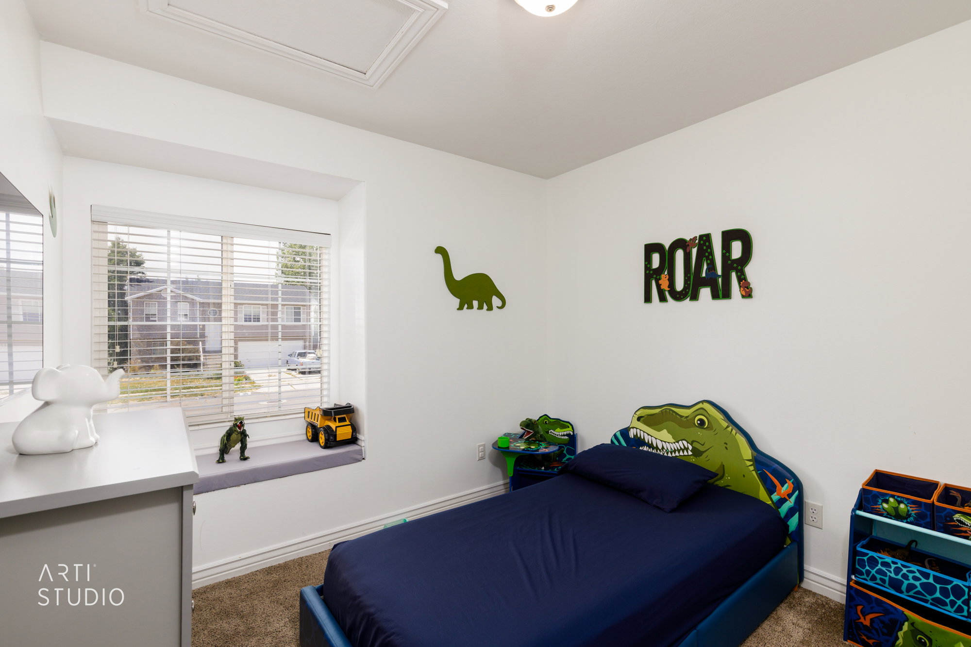 Bedroom featuring a window with integrated seating and blinds