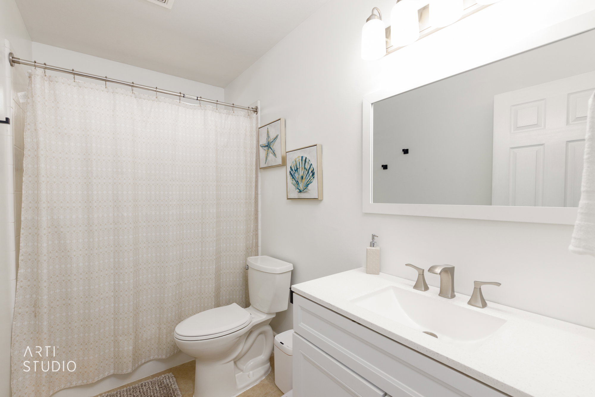 Bathroom featuring a spacious vanity with an integrated sink, brushed nickel faucet, and a large framed mirror