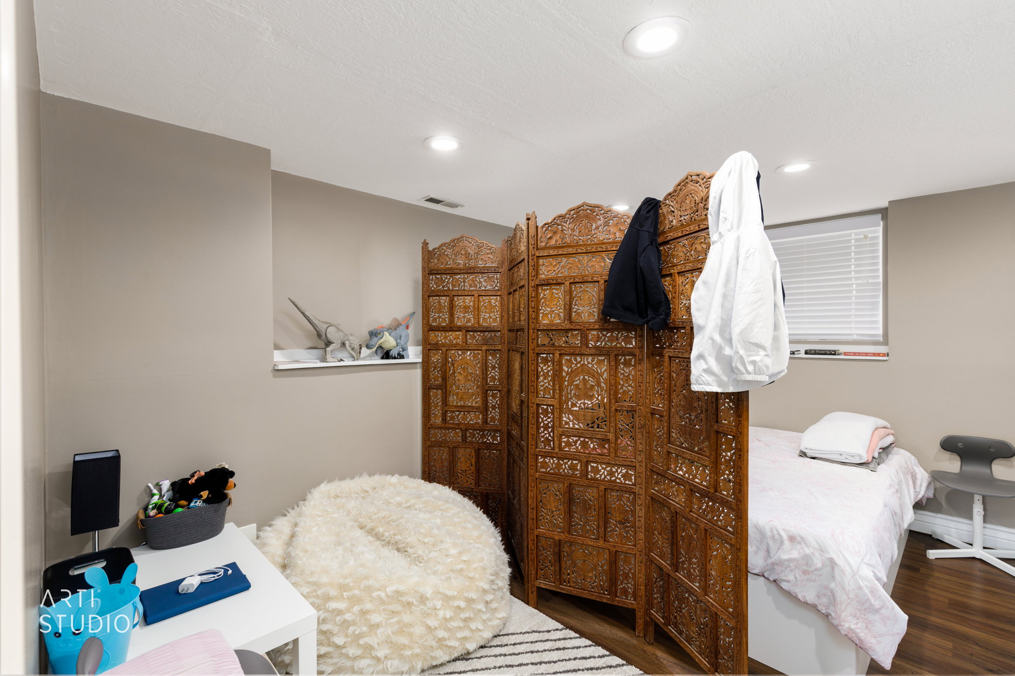 Recessed lighting illuminates neutral-toned walls and wood-finish flooring