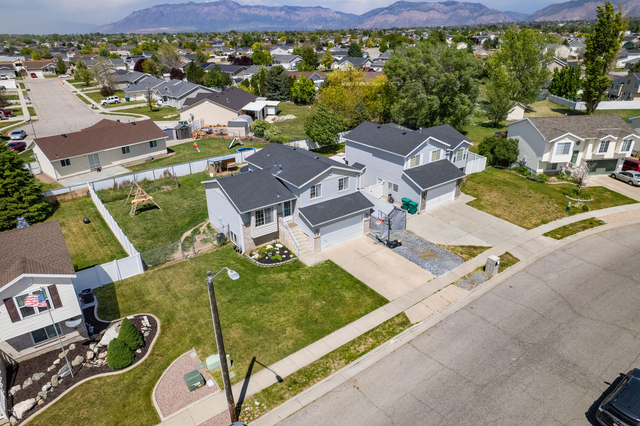 Modern residential property featuring a two-story design with a light gray exterior and dark gray shingled roof