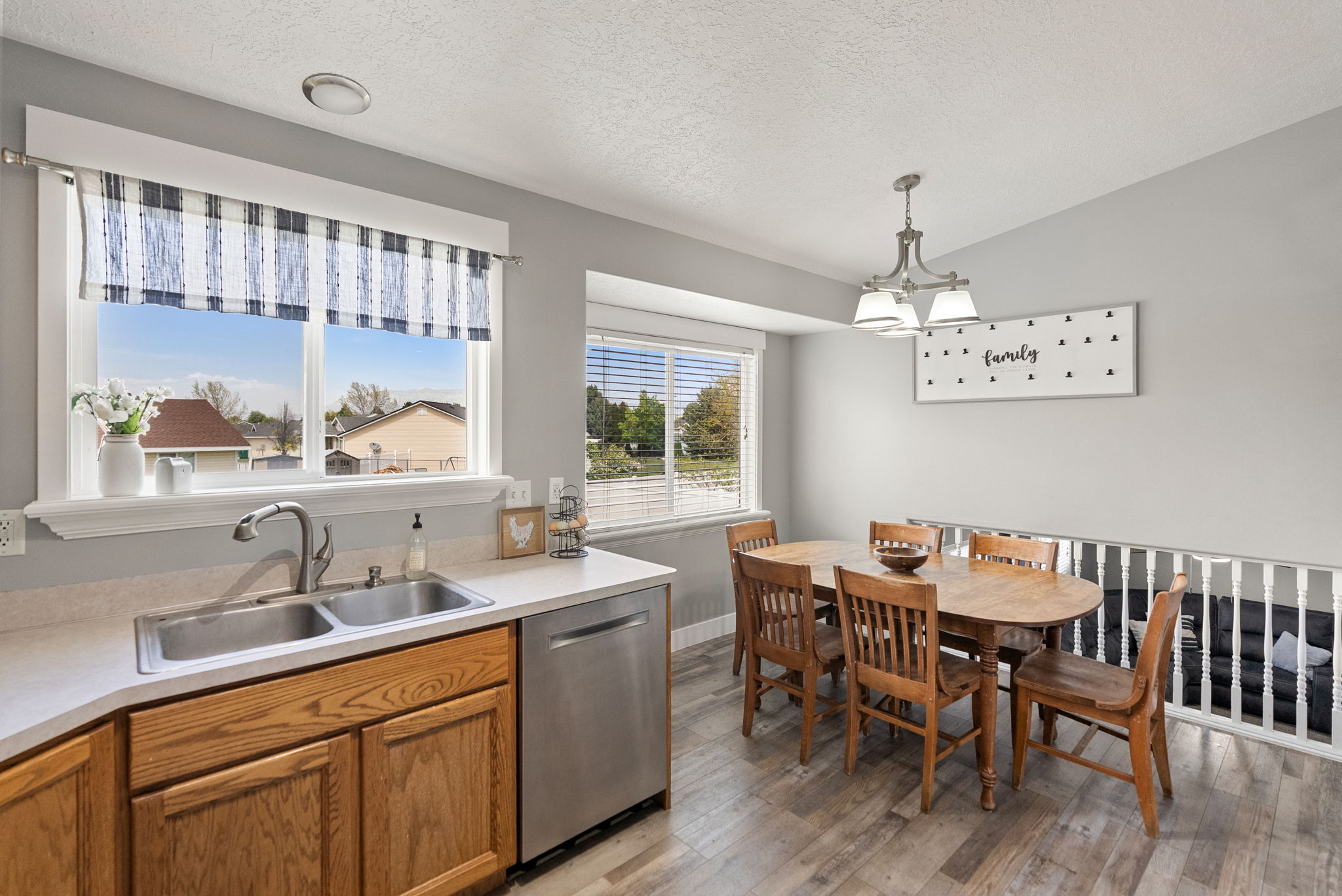 Kitchen and dining area featuring wood-finish flooring, light gray wall paint, and white trim