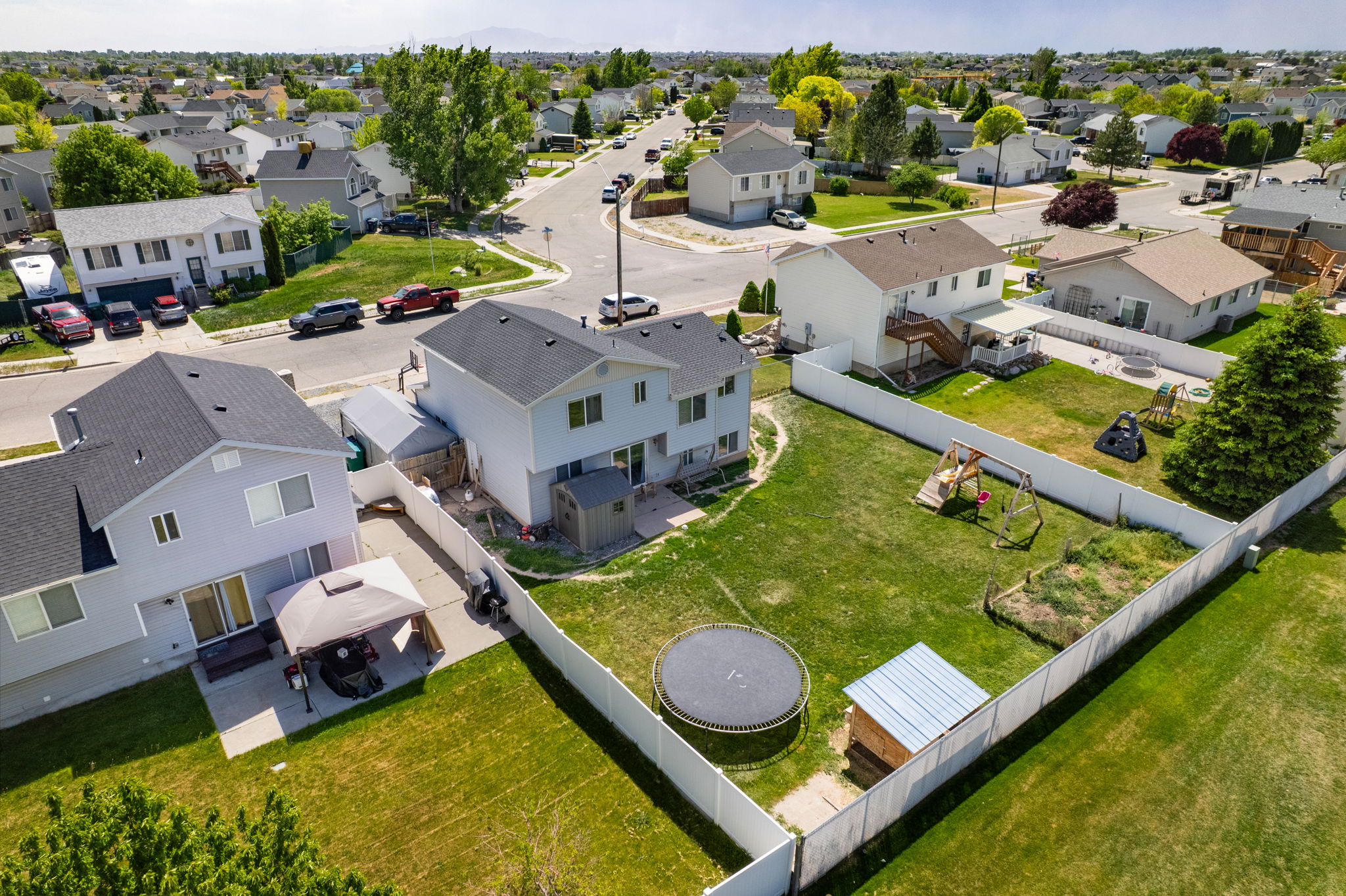 Expansive fenced backyard featuring a grassy lawn and a storage shed