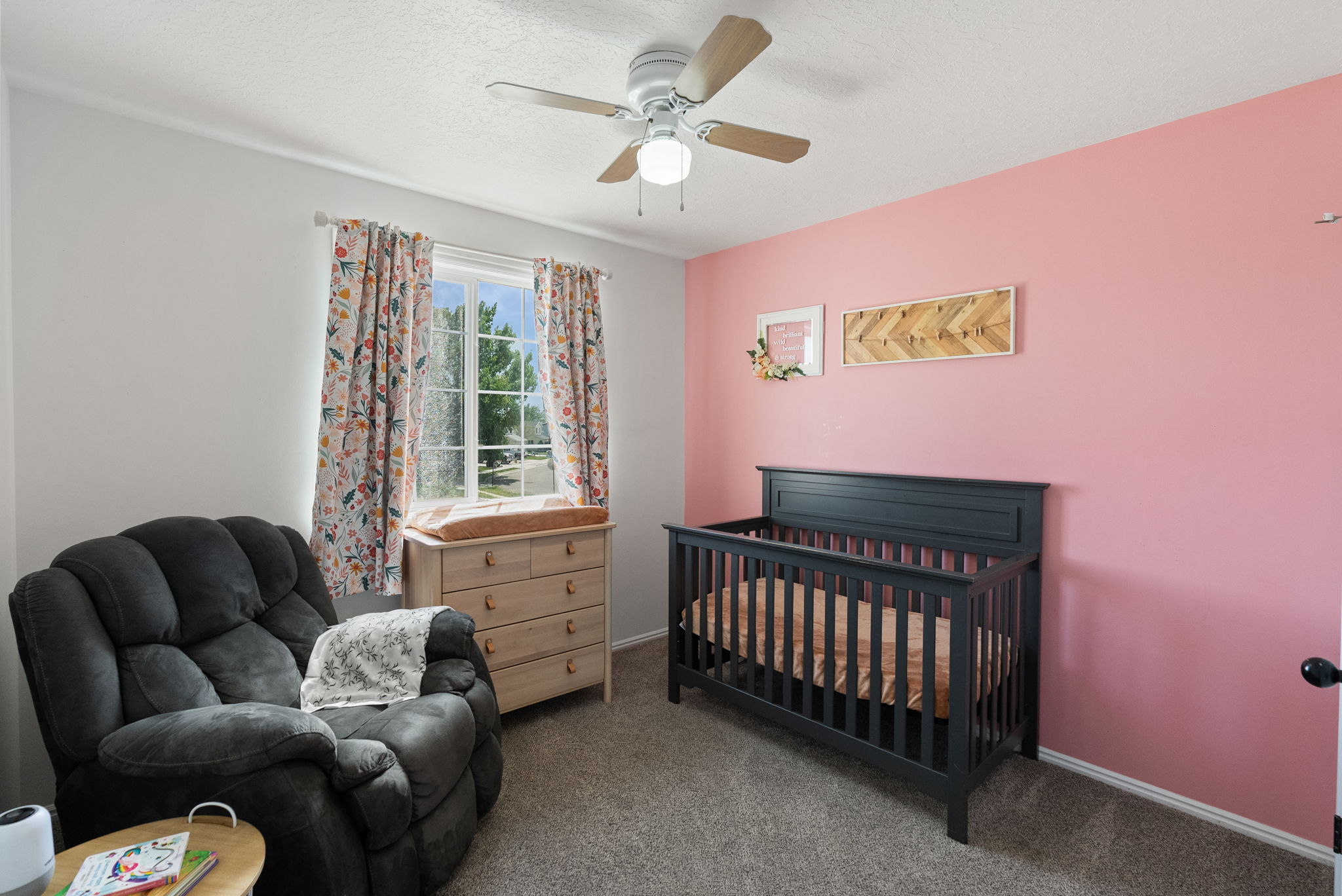 Carpeted room with a ceiling fan light fixture