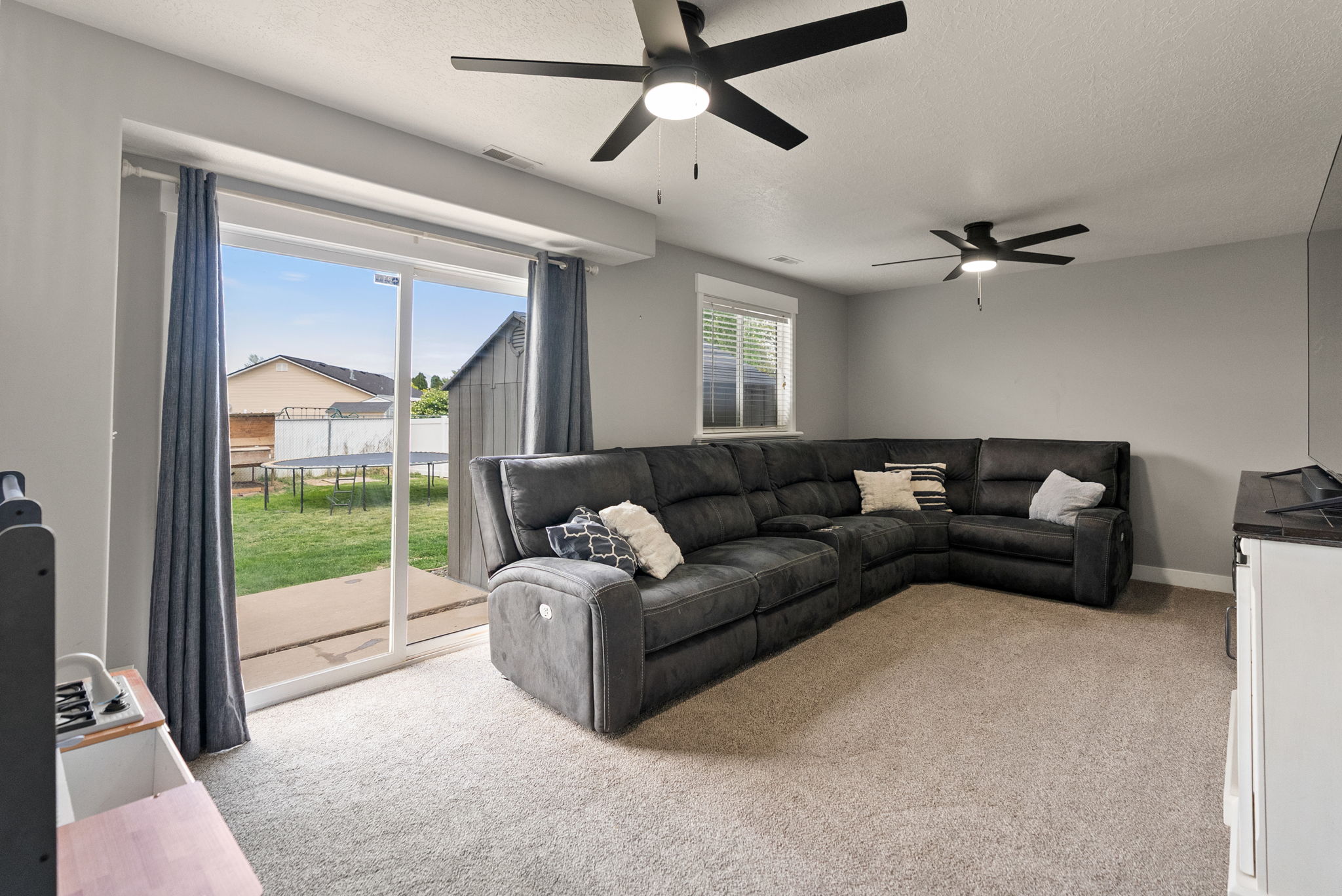 Spacious living area featuring neutral carpeting and light gray wall paint