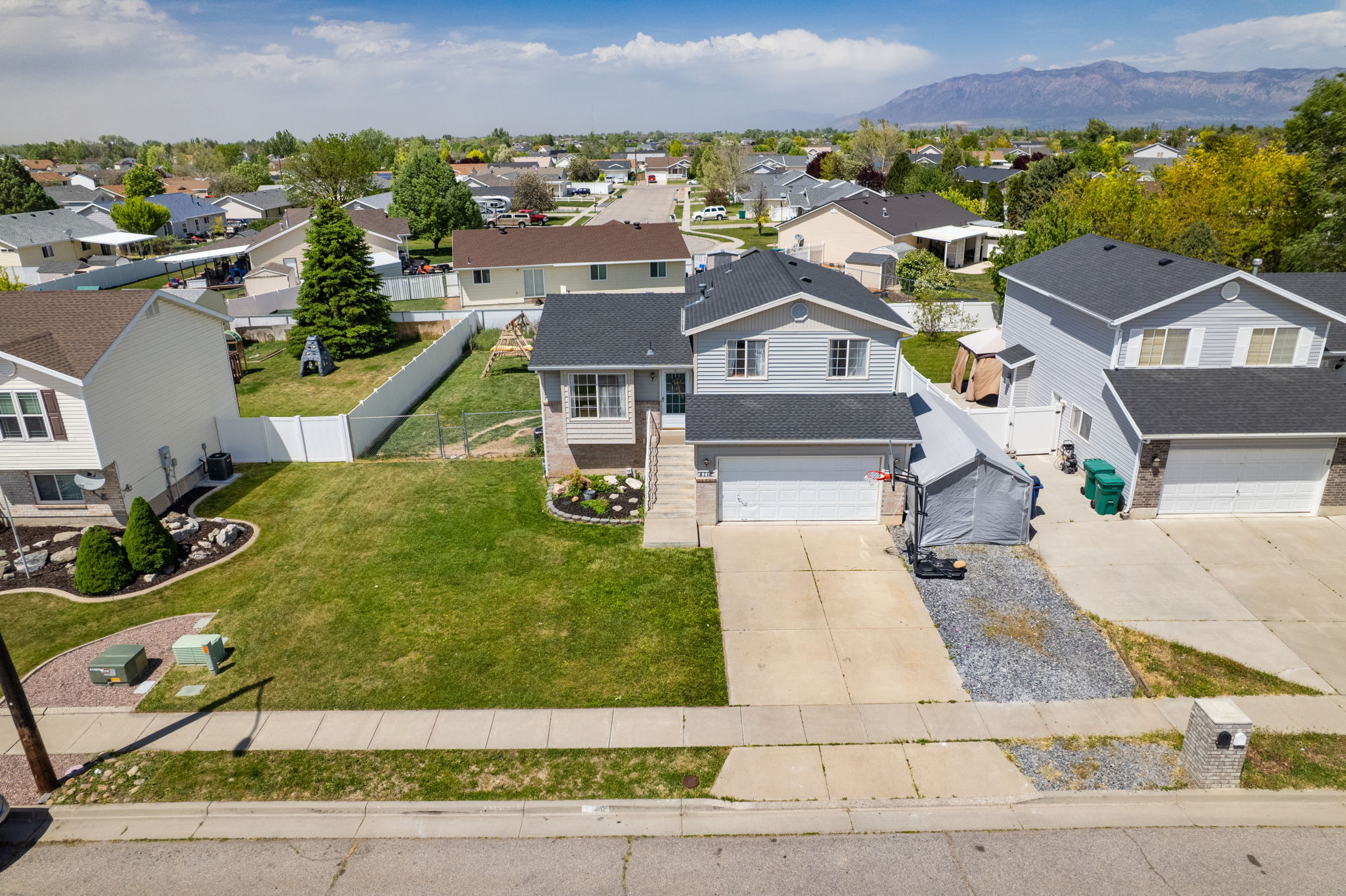 Two-story home featuring a two-car garage, concrete driveway, and a well-maintained front lawn
