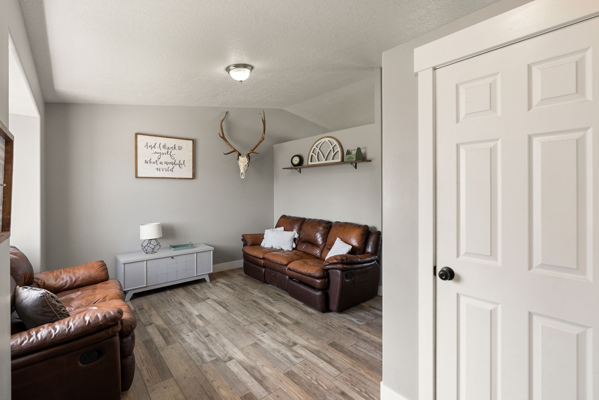 Warm living space featuring wood-finish flooring and light gray painted walls