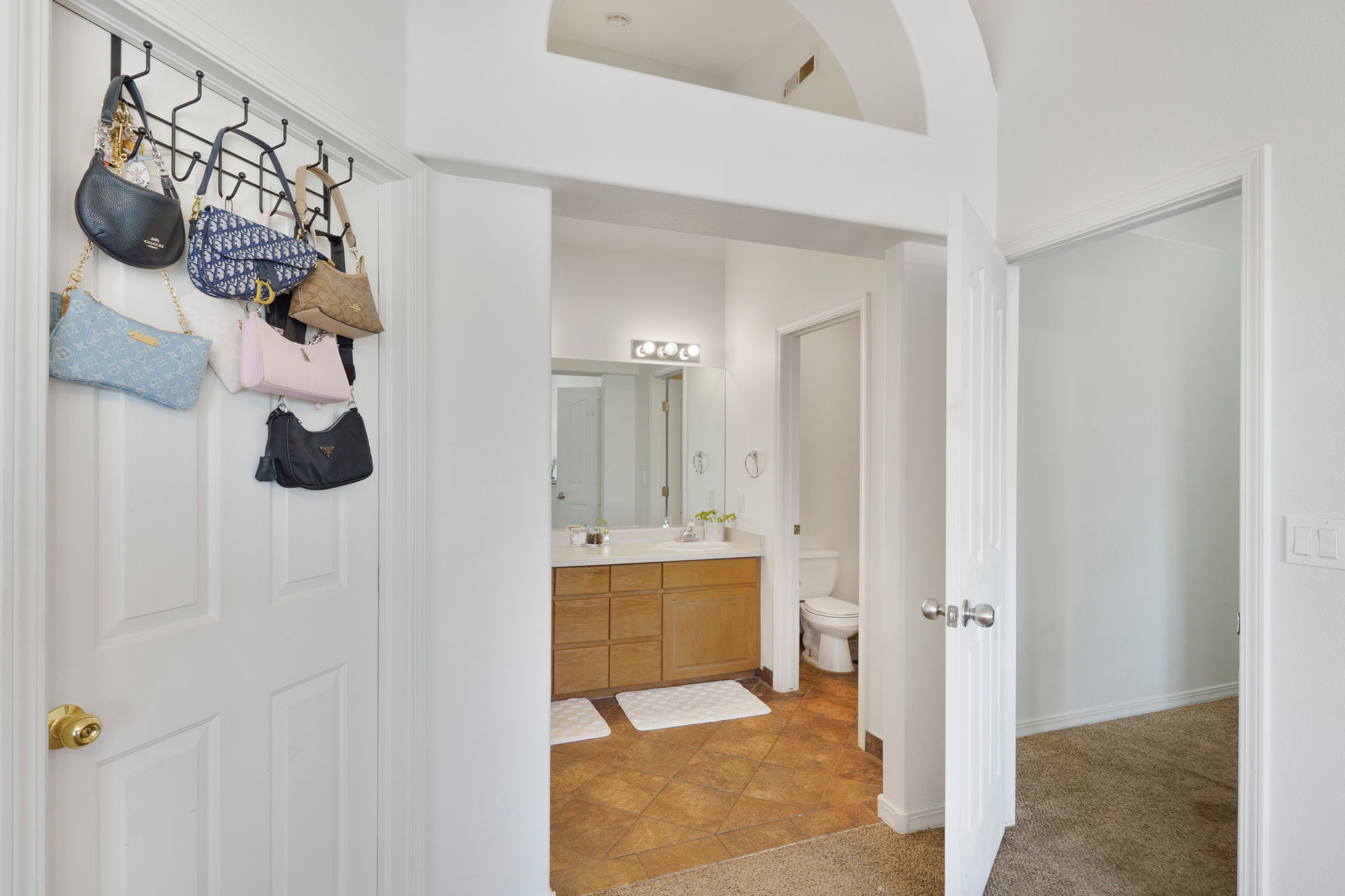 Bathroom featuring a dual vanity with a light wood-finish cabinet and a white countertop