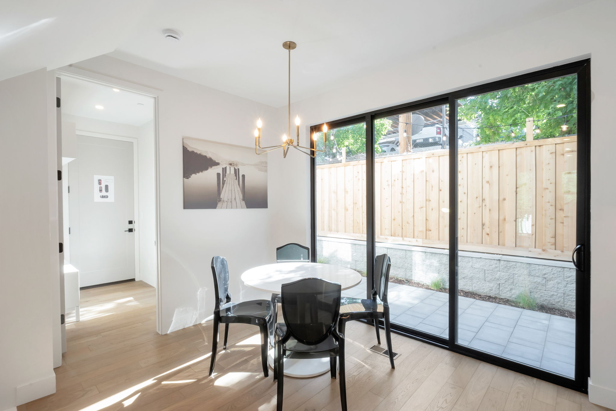 Dining area featuring wide plank wood-finish flooring and a contemporary chandelier