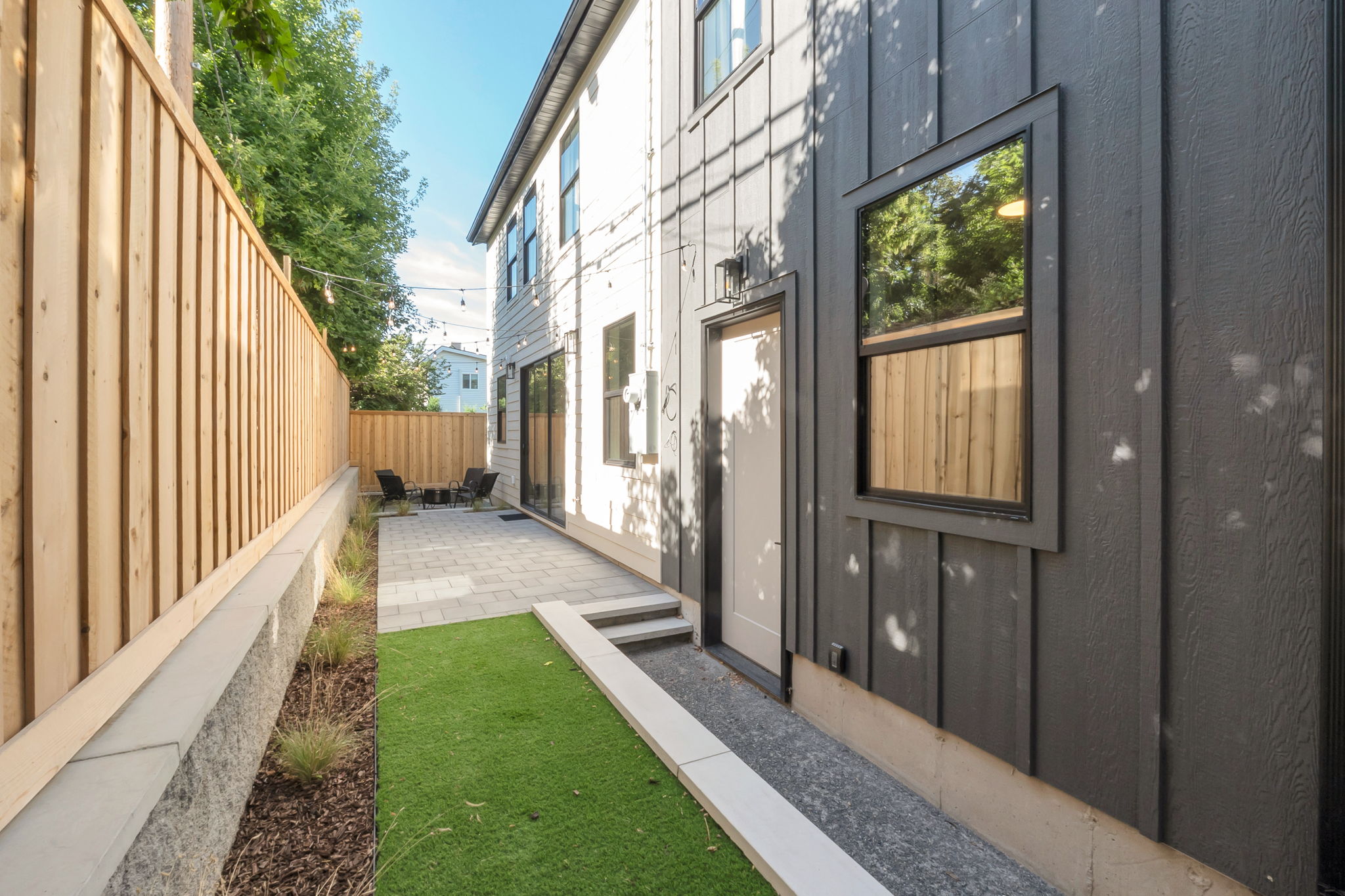 Modern exterior featuring dark vertical siding and a contrasting light entry door