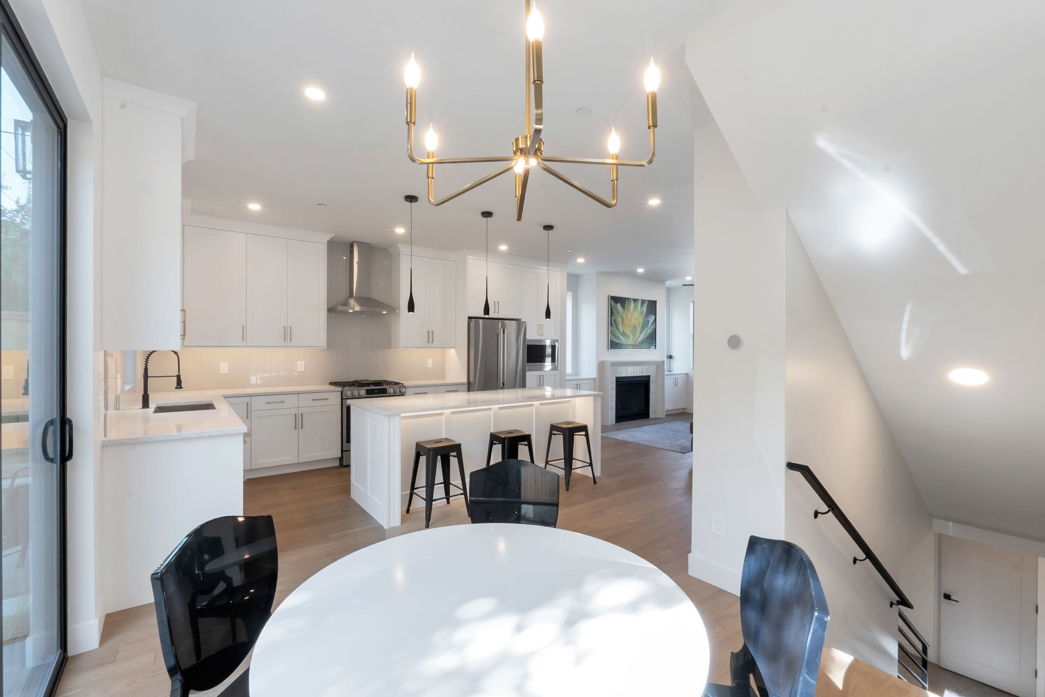 Modern kitchen featuring white cabinetry, light-toned countertops, and a central island with bar seating