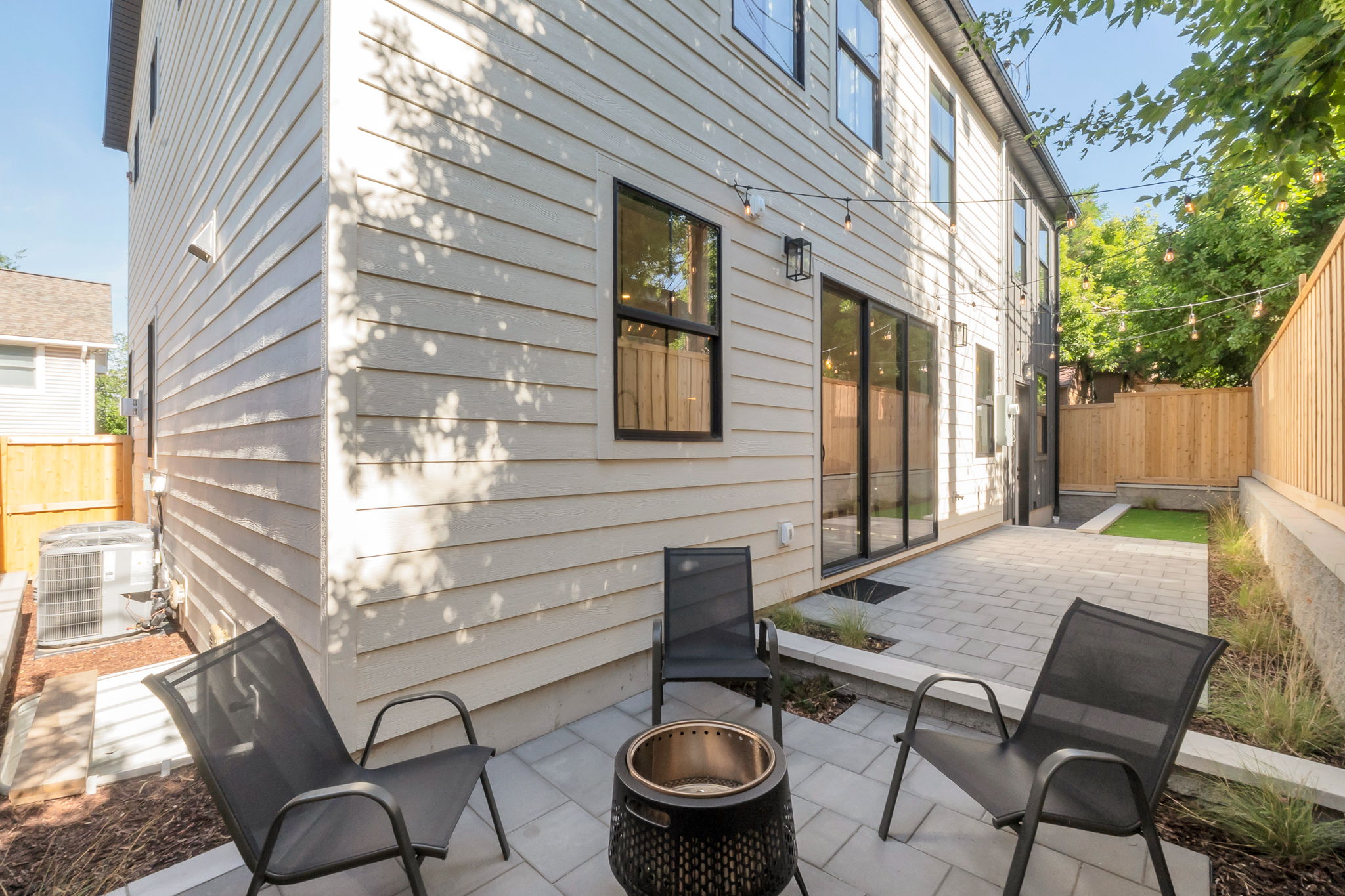 Outdoor patio featuring paver stones, siding exterior, and privacy fencing