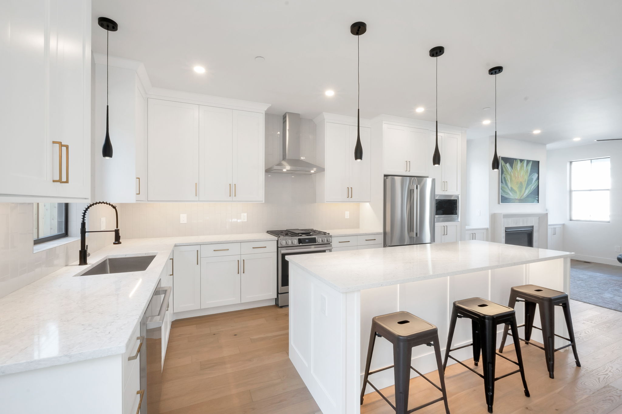 Kitchen featuring white cabinetry, light-toned countertops, and wood-finish flooring