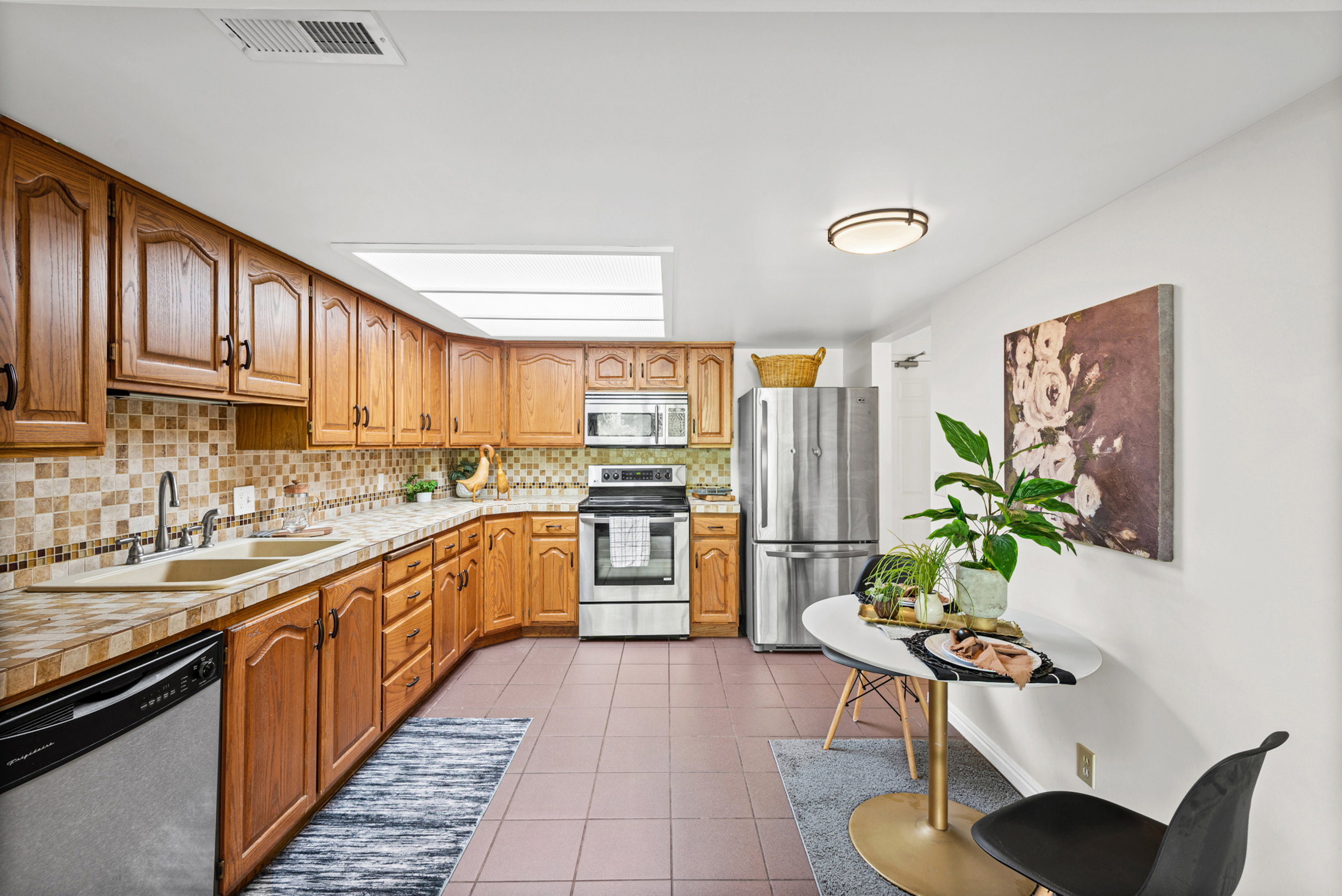 Kitchen with wood cabinetry, stainless steel appliances, and a tiled backsplash