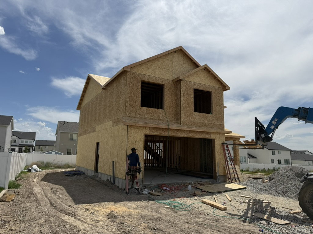 New construction home in framing stage featuring a two-story design and attached garage