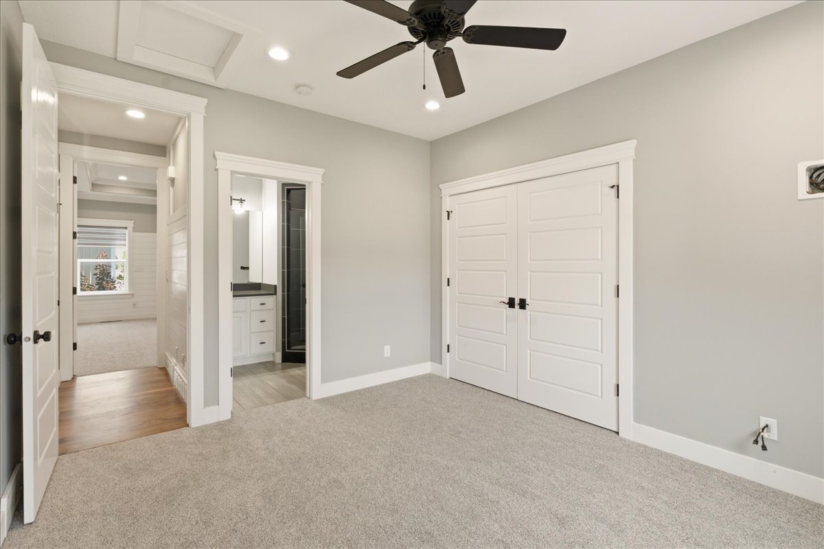 Carpeted room featuring a ceiling fan with light, recessed lighting, and white bi-fold closet doors with black hardware