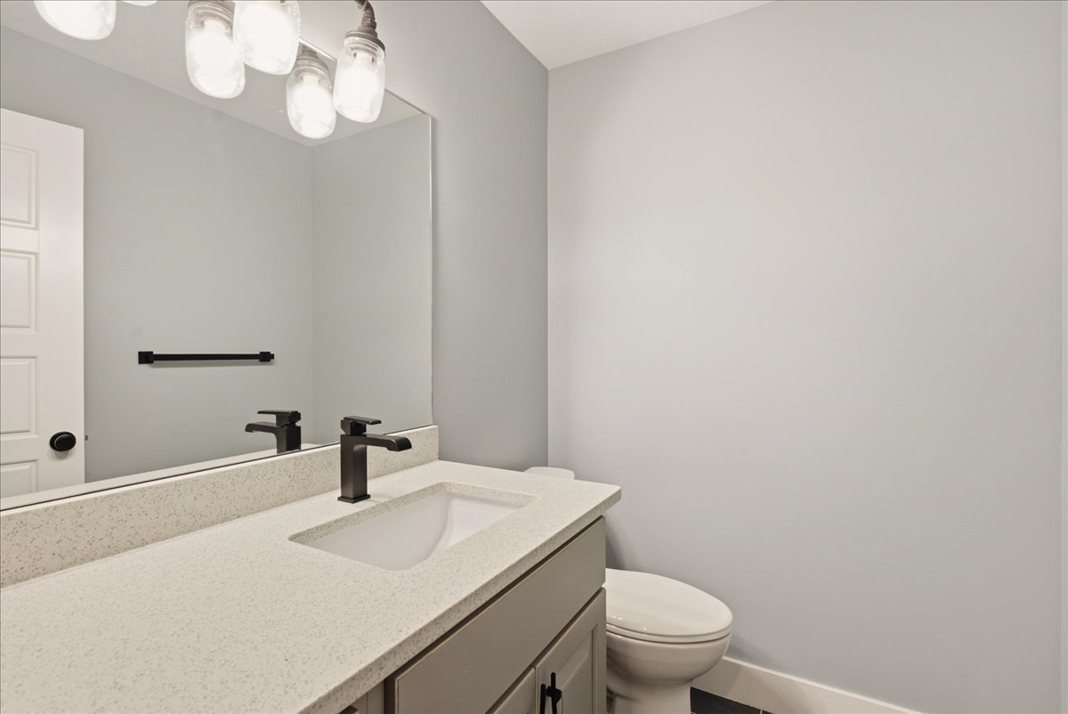 Bathroom featuring a neutral color palette, integrated sink, and dark bronze fixtures