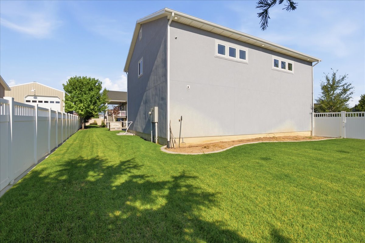 Expansive green lawn with vinyl fencing enclosing the property perimeter