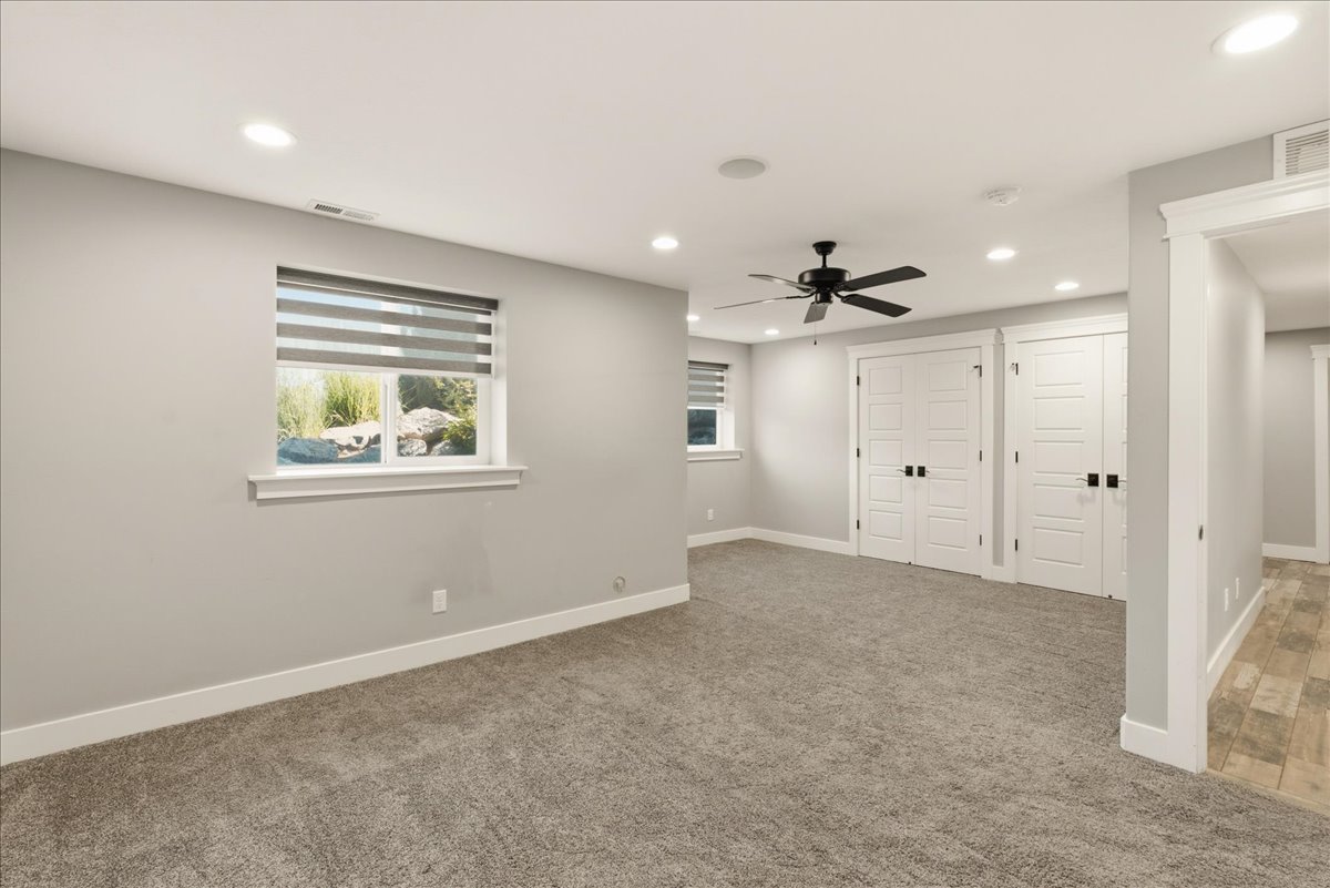 Spacious room featuring neutral carpeting, recessed lighting, and a ceiling fan