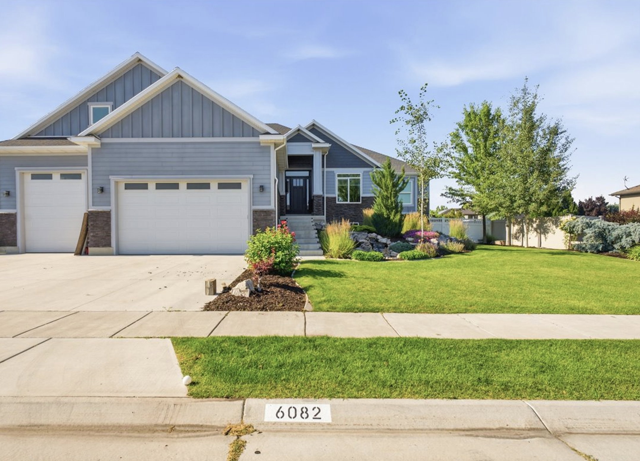 Contemporary residence featuring a light blue and gray exterior with stone accents
