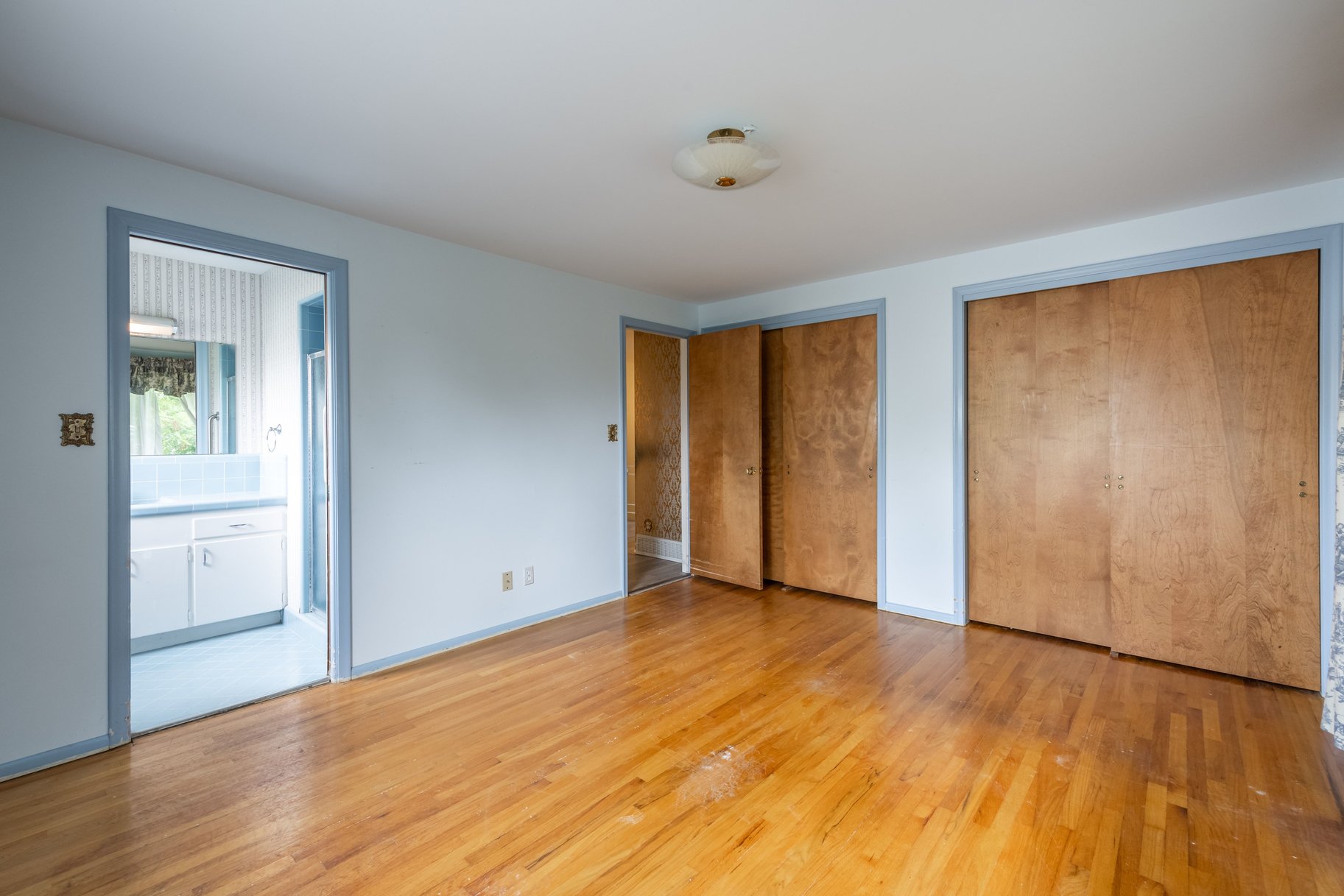 Hardwood flooring throughout, two light wood-finish sliding closet doors, and recessed ceiling light fixture